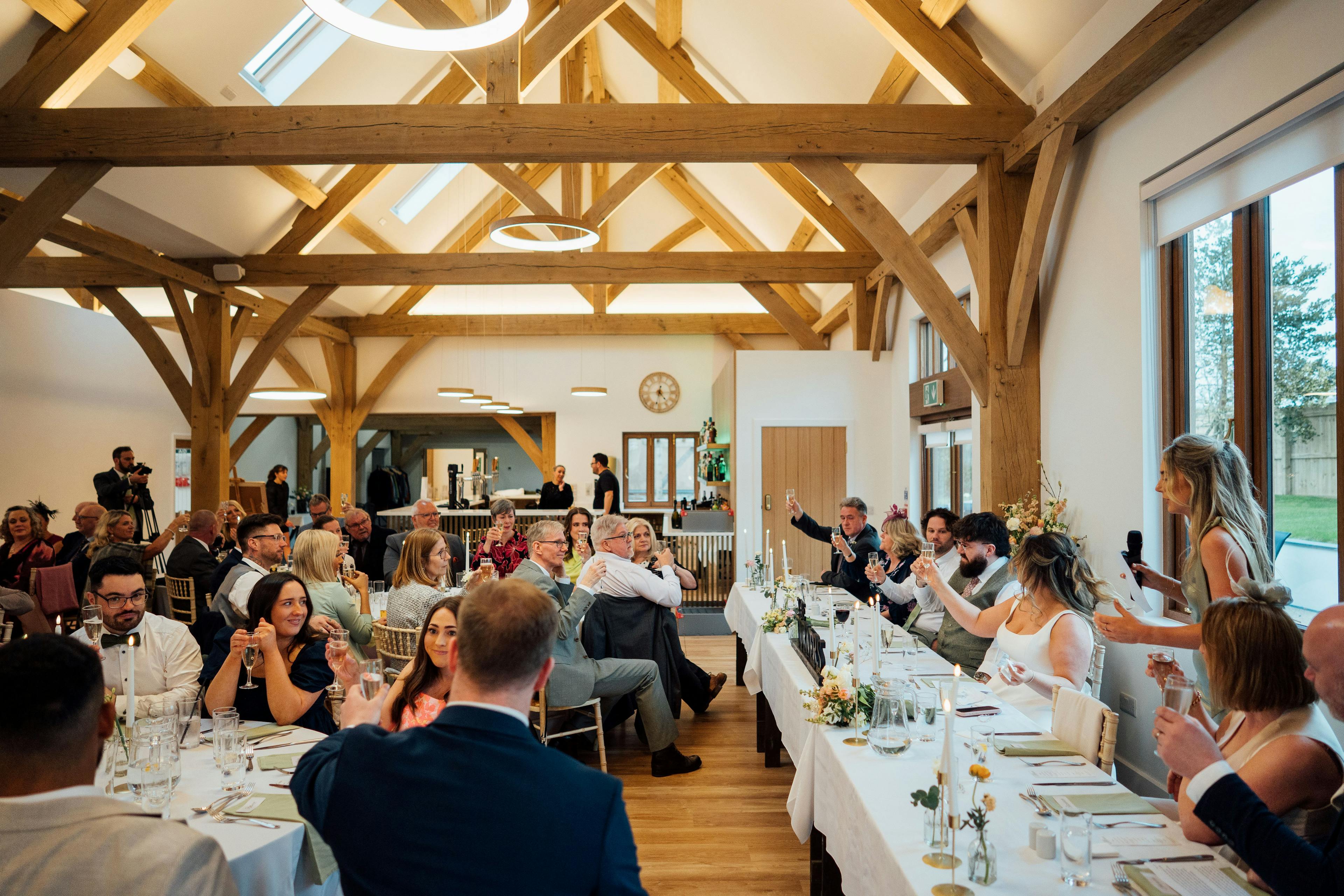 An oak framed wedding barn guests sat at tables