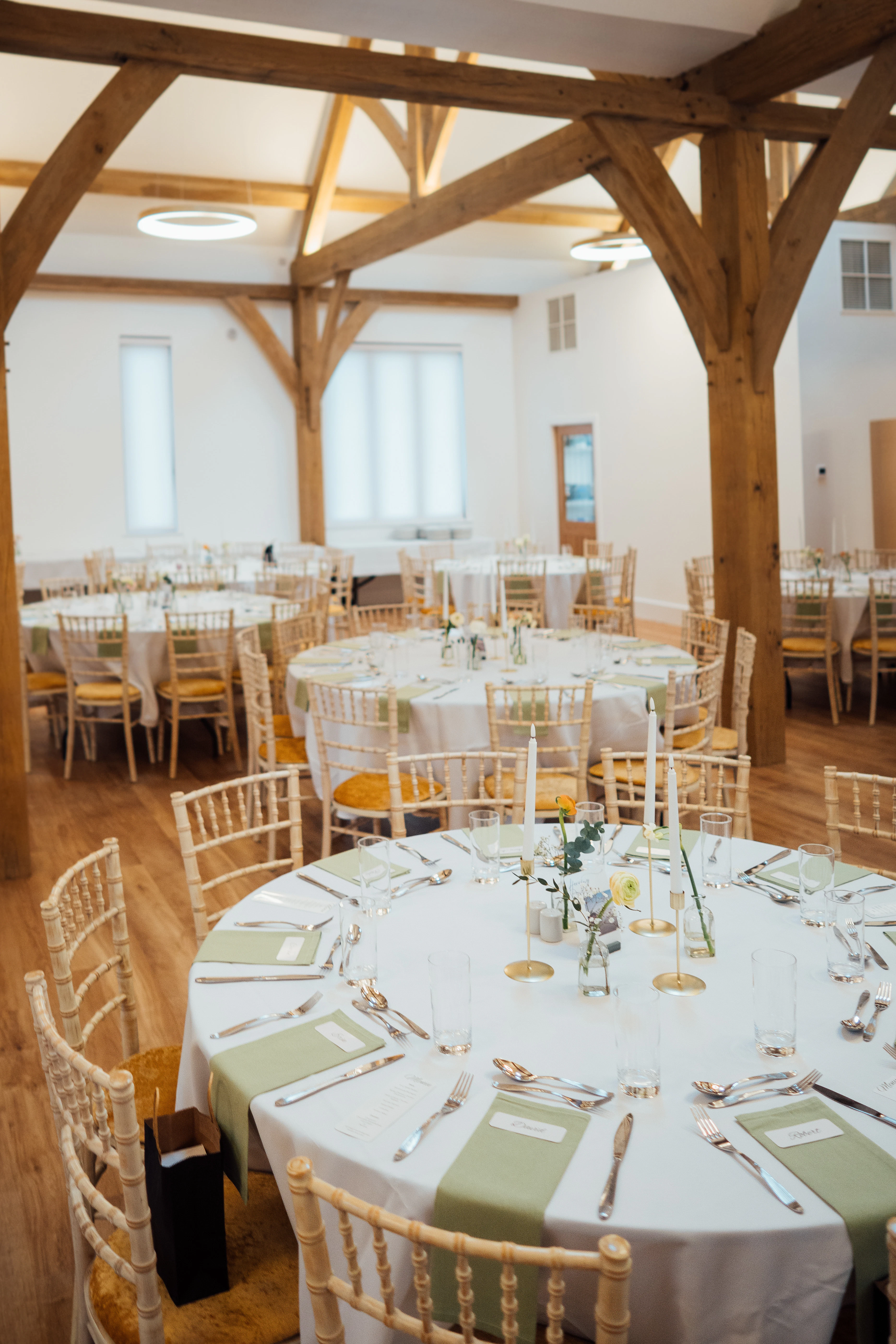 An oak framed wedding barn with tables and chairs set up ready for guests