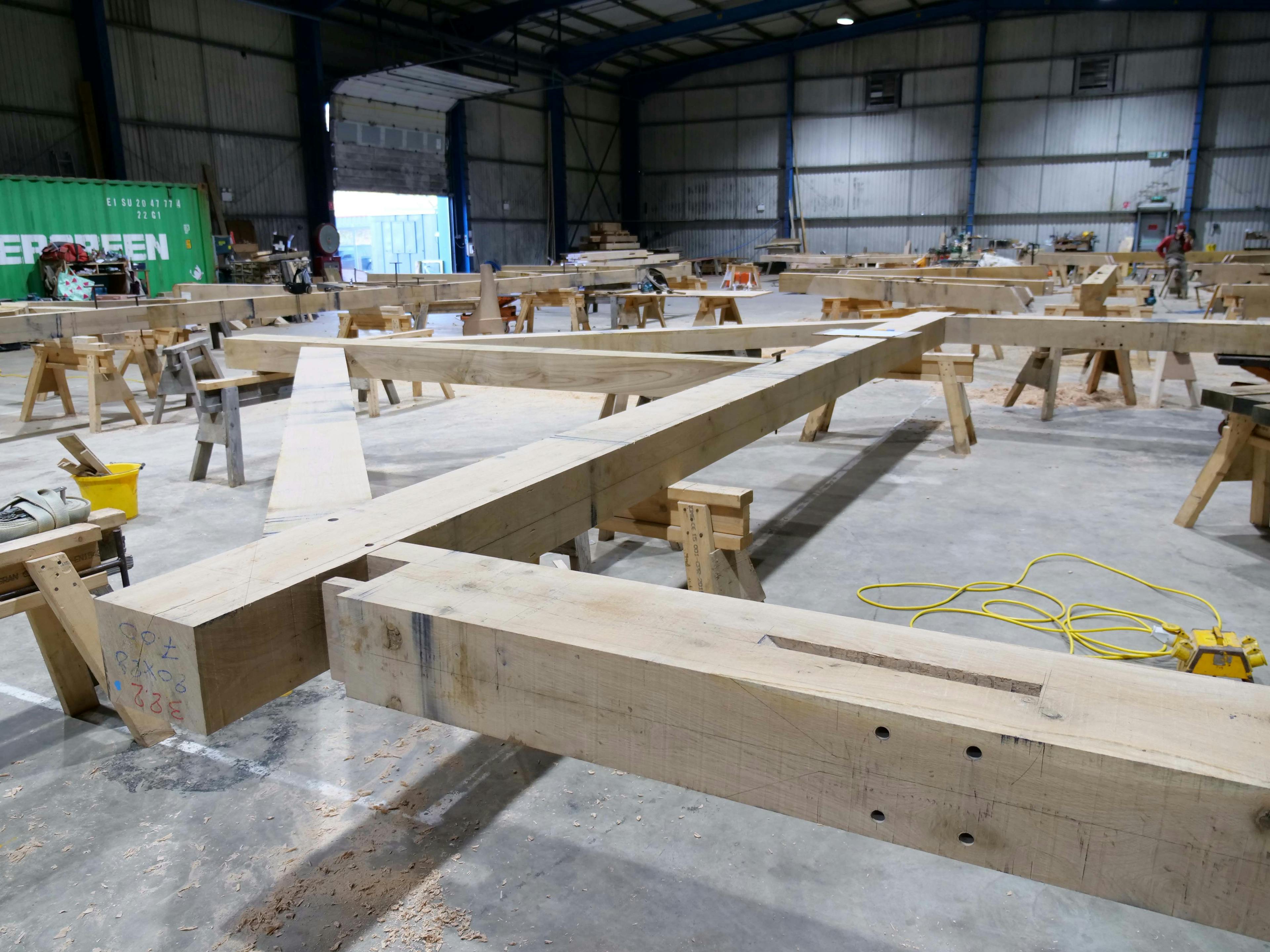 An oak frame wedding barn during handcrafted construction in a workshop