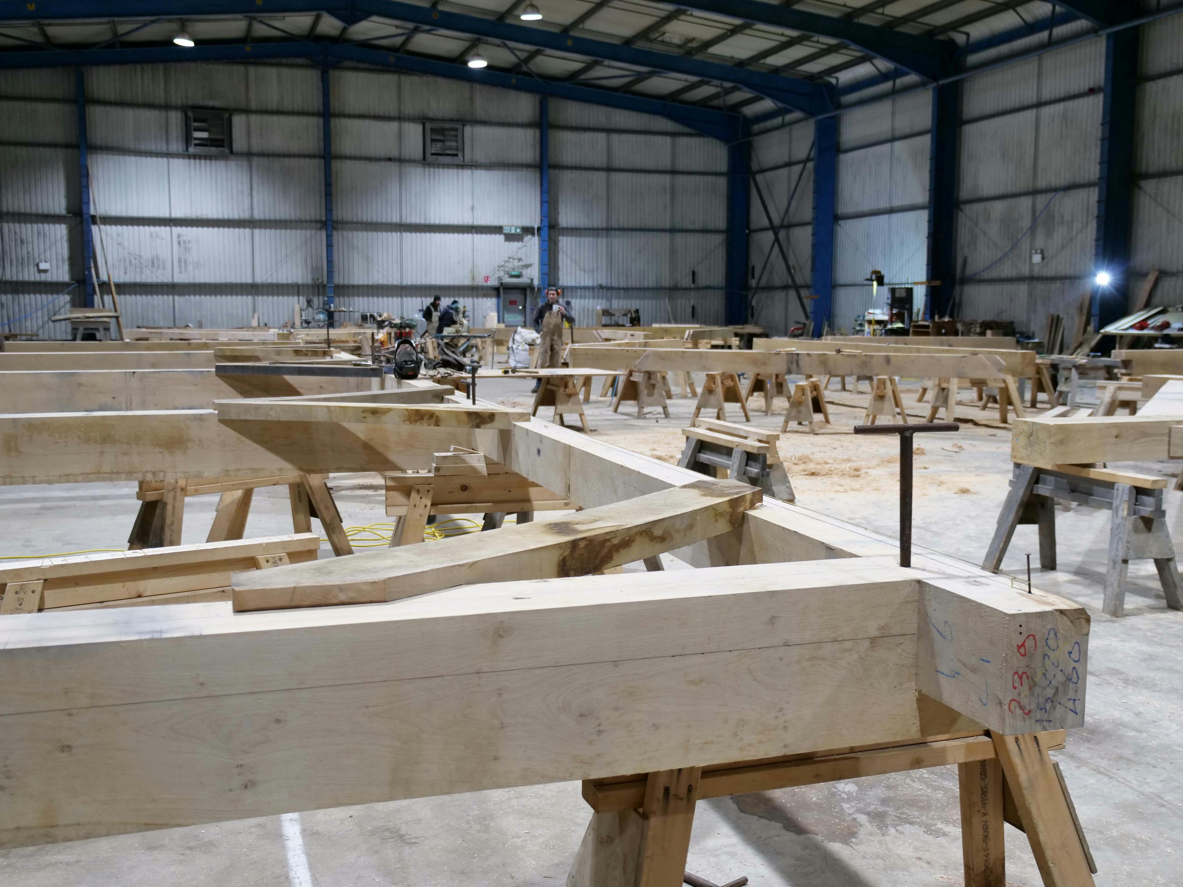 An oak frame wedding barn during handcrafted construction in a workshop