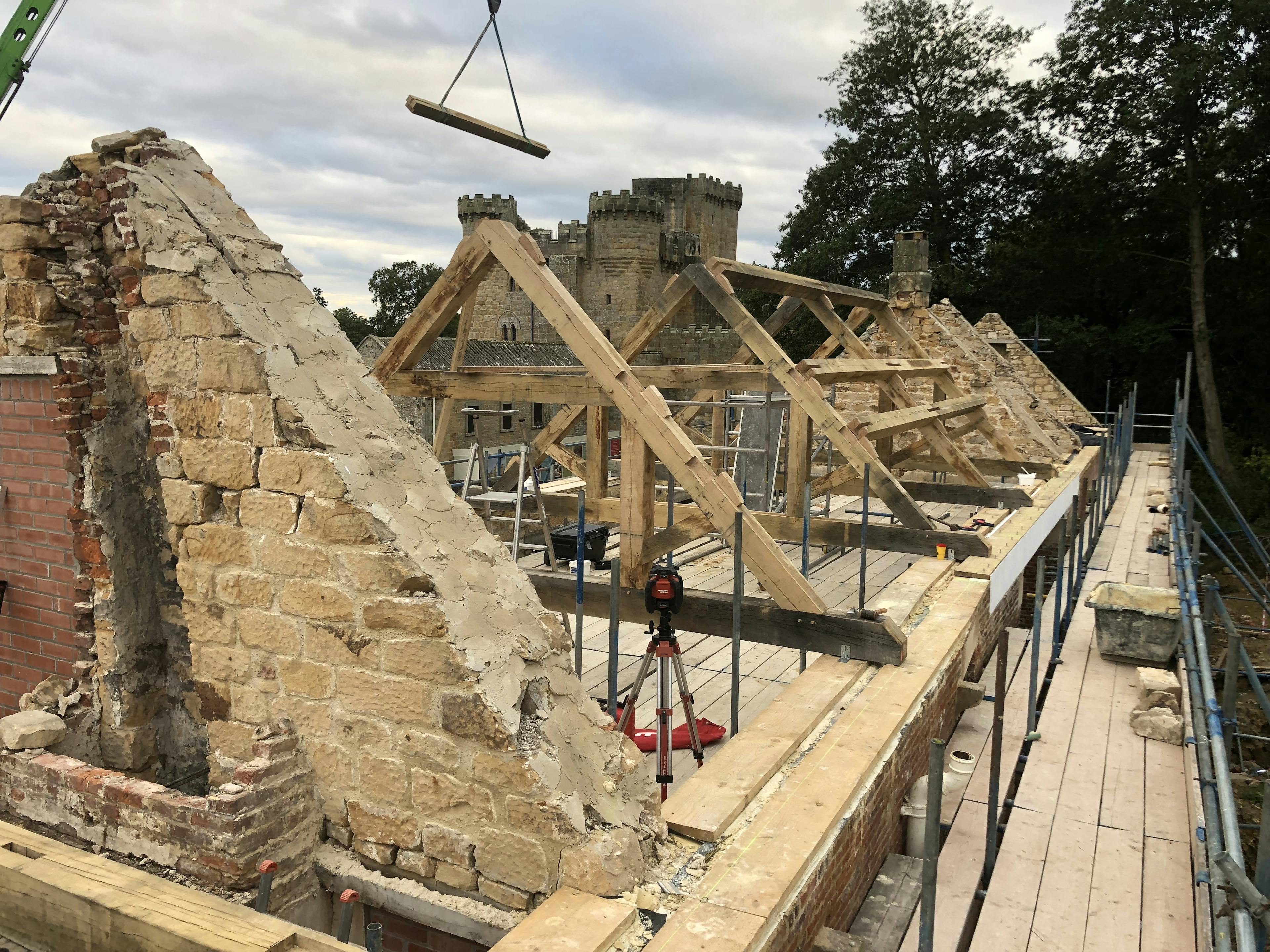 Oak trusses being installed in a renovated coach house to create a new cafe for visitors to Belsay Hall