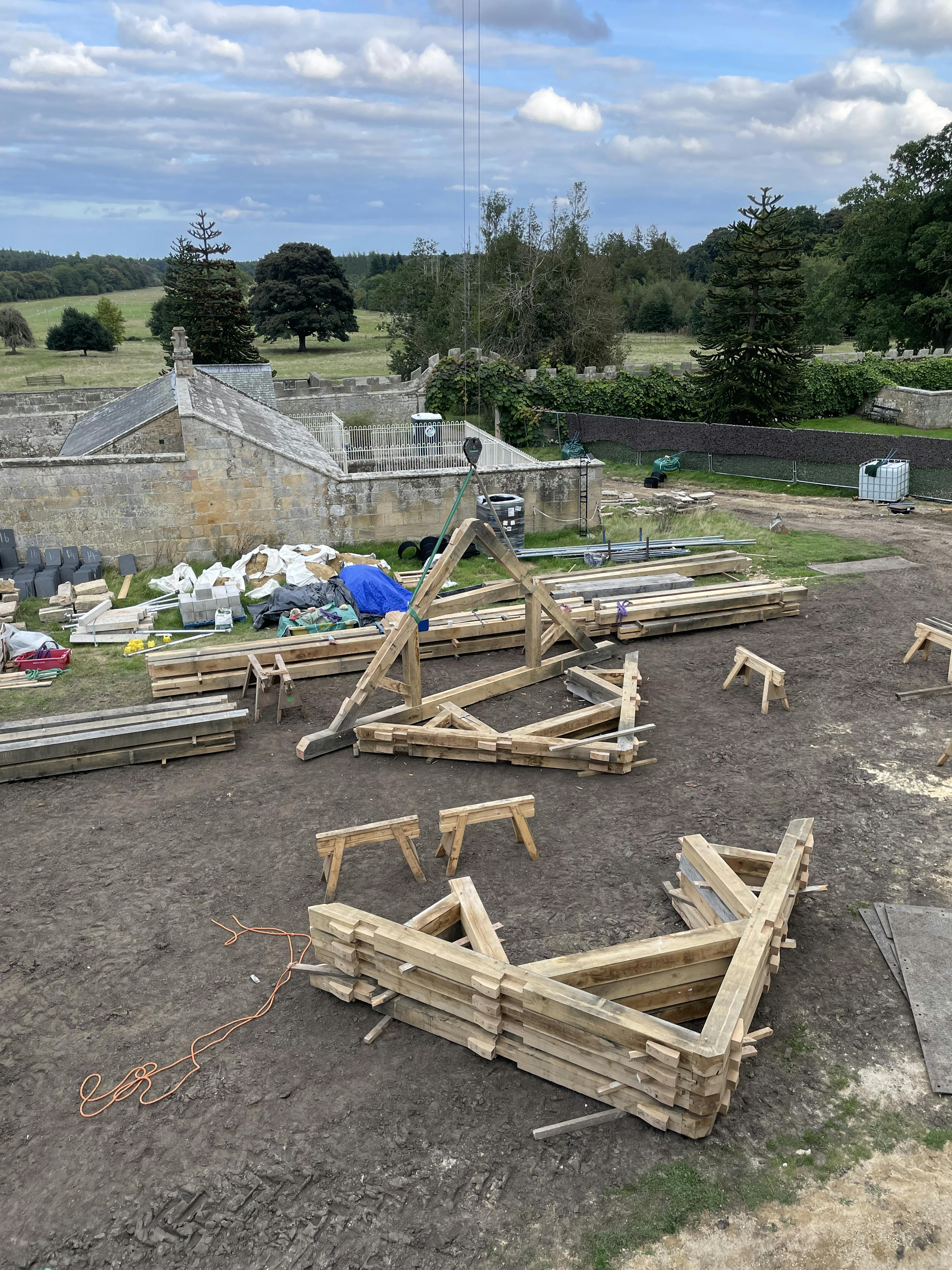 Oak trusses on the ground ready to be installed in a renovated coach house to create a new cafe for visitors to Belsay Hall