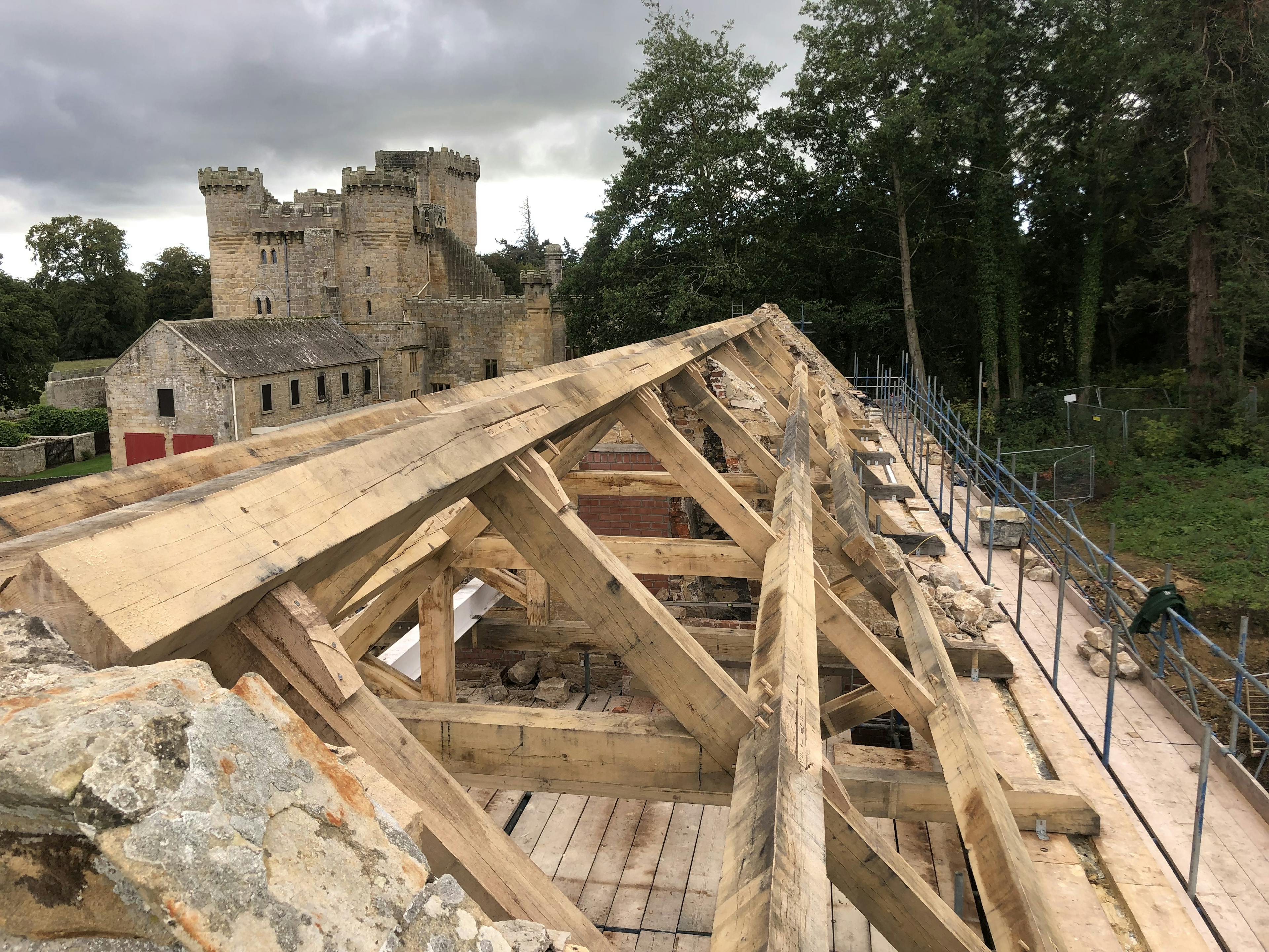Oak trusses being installed in a renovated coach house to create a new cafe for visitors to Belsay Hall
