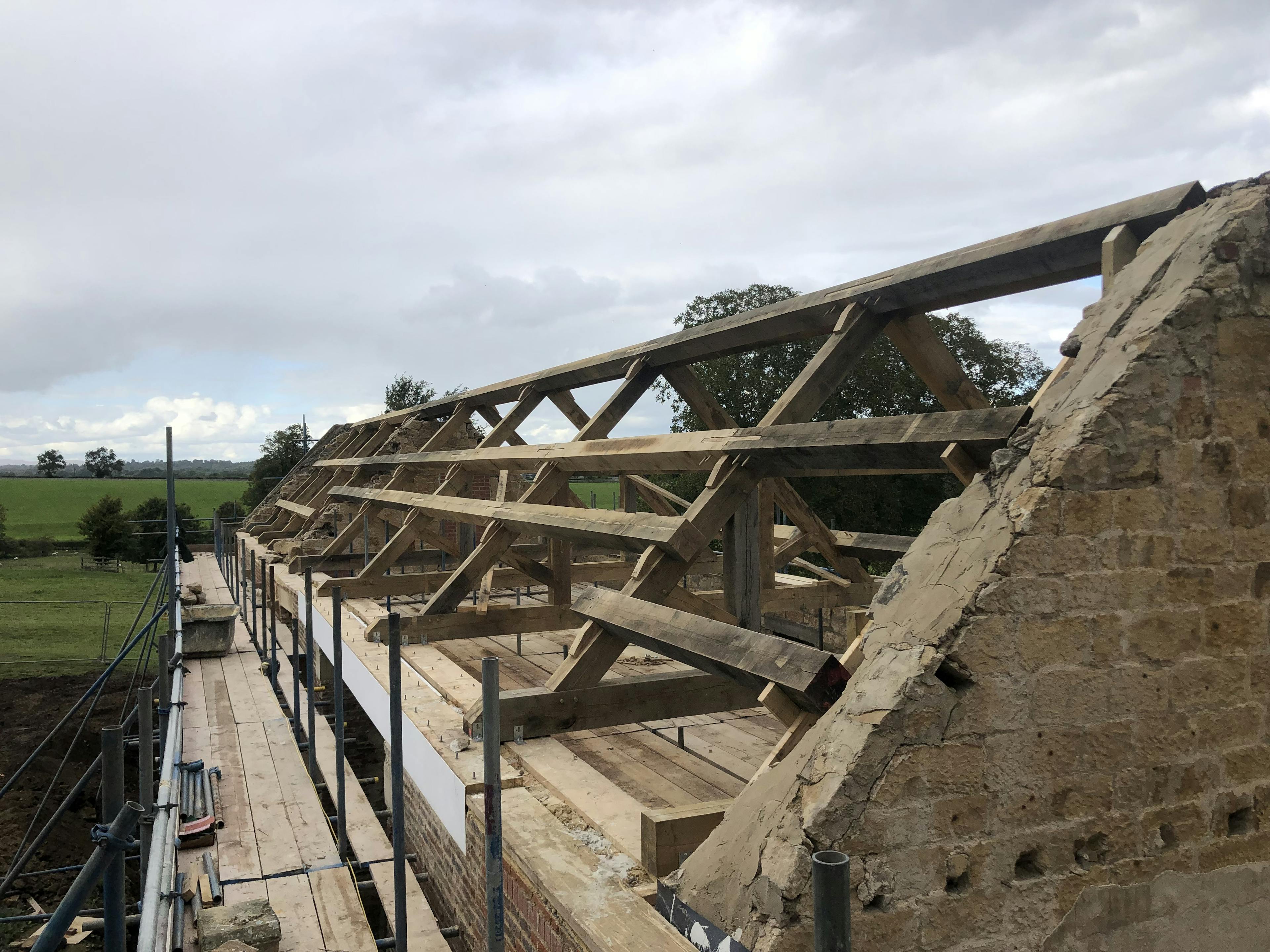 Oak trusses being installed in a renovated coach house to create a new cafe for visitors to Belsay Hall