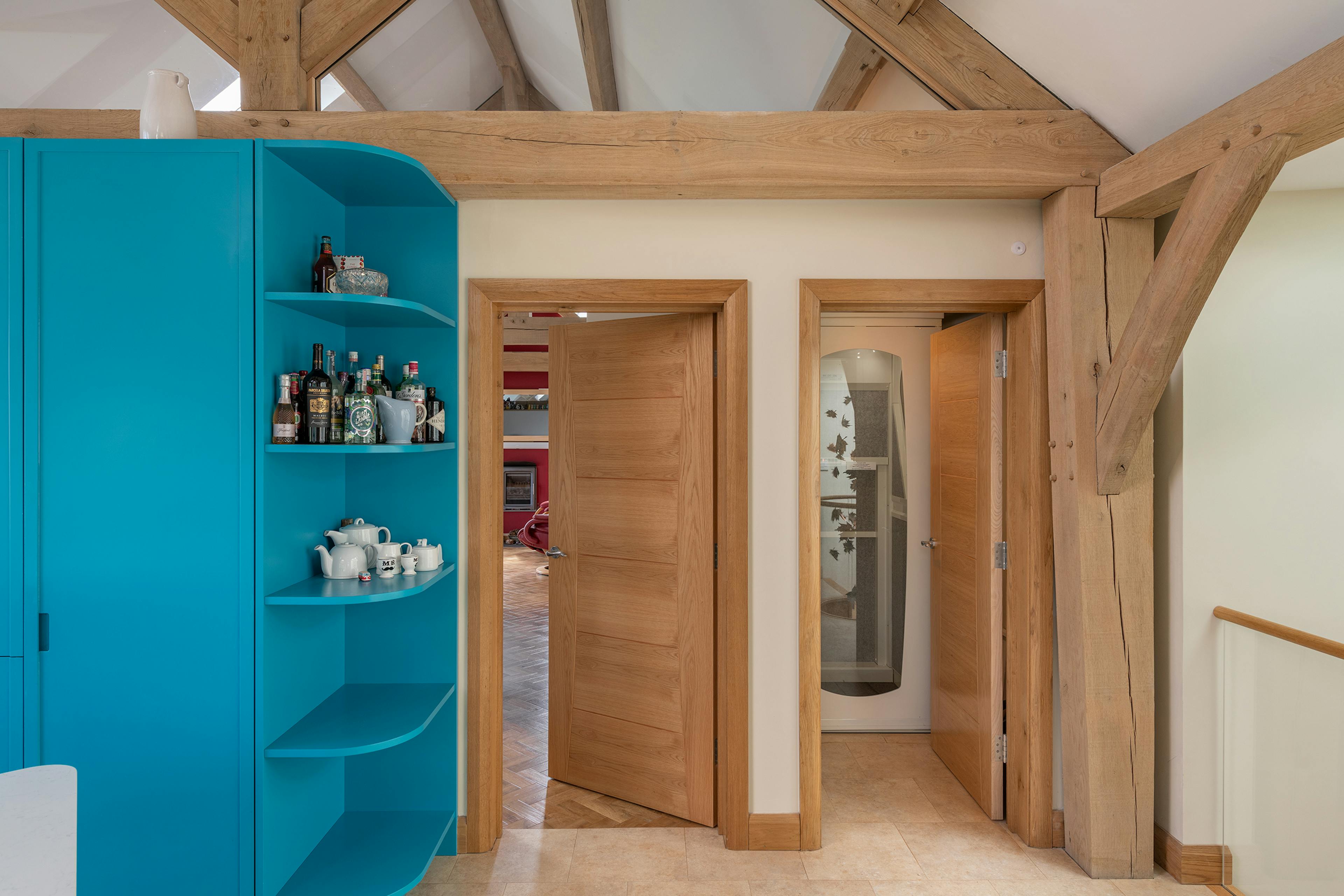 Kitchen shelving in an oak frame home next to a lift / elevator