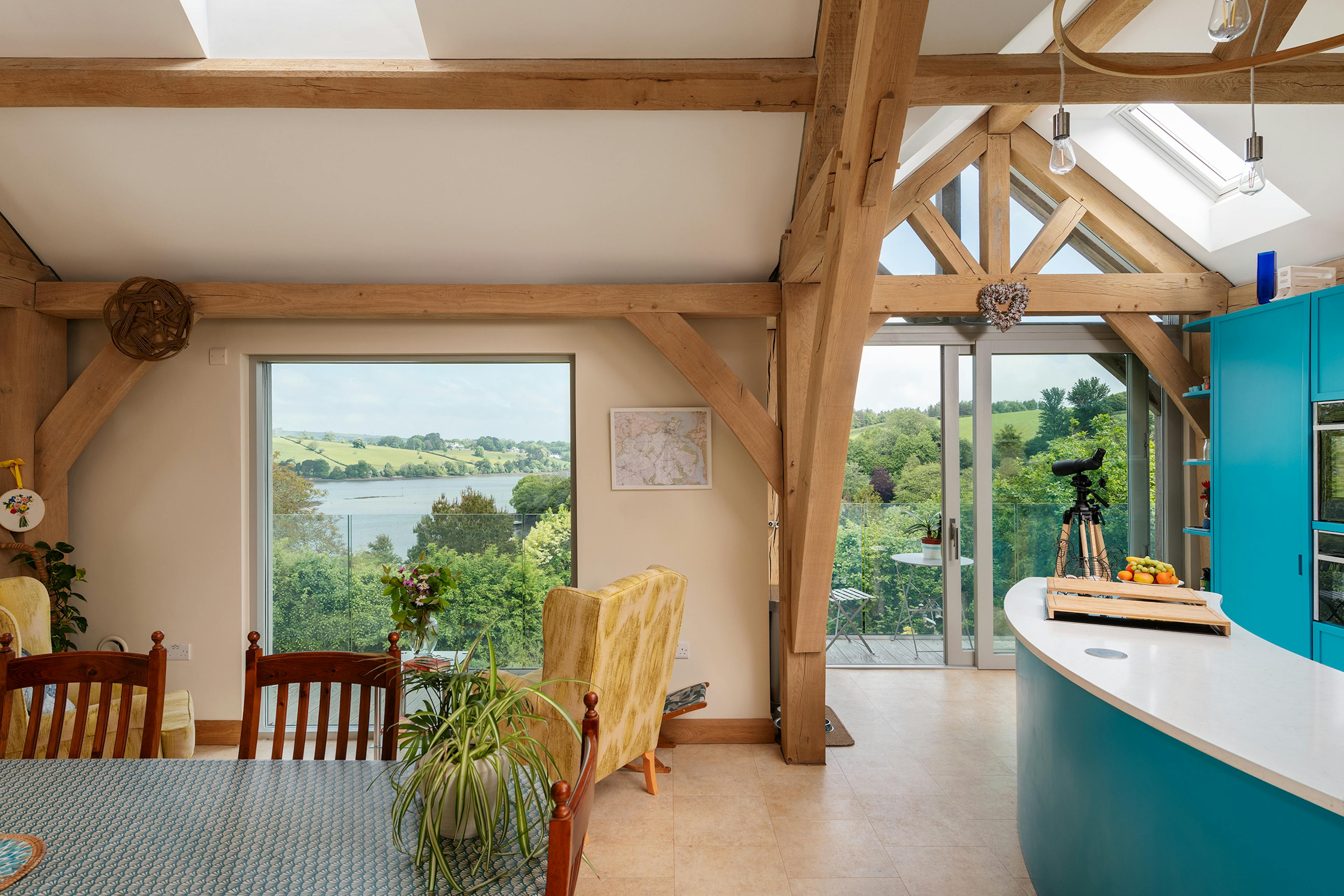 A vaulted ceiling in an oak framed open plan kitchen and dining room with views of the estuary