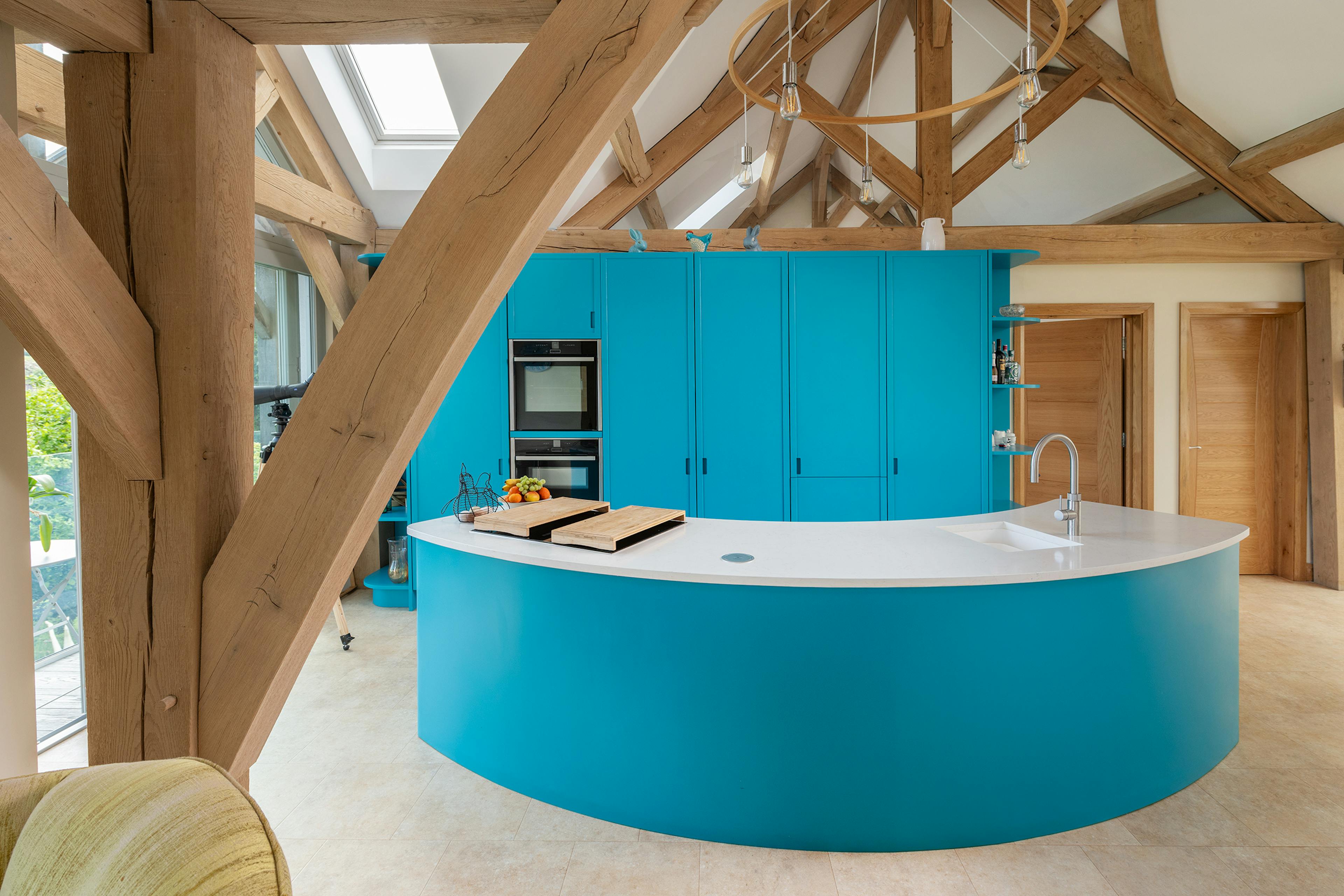 A vaulted ceiling in an oak framed kitchen with a curved kitchen island