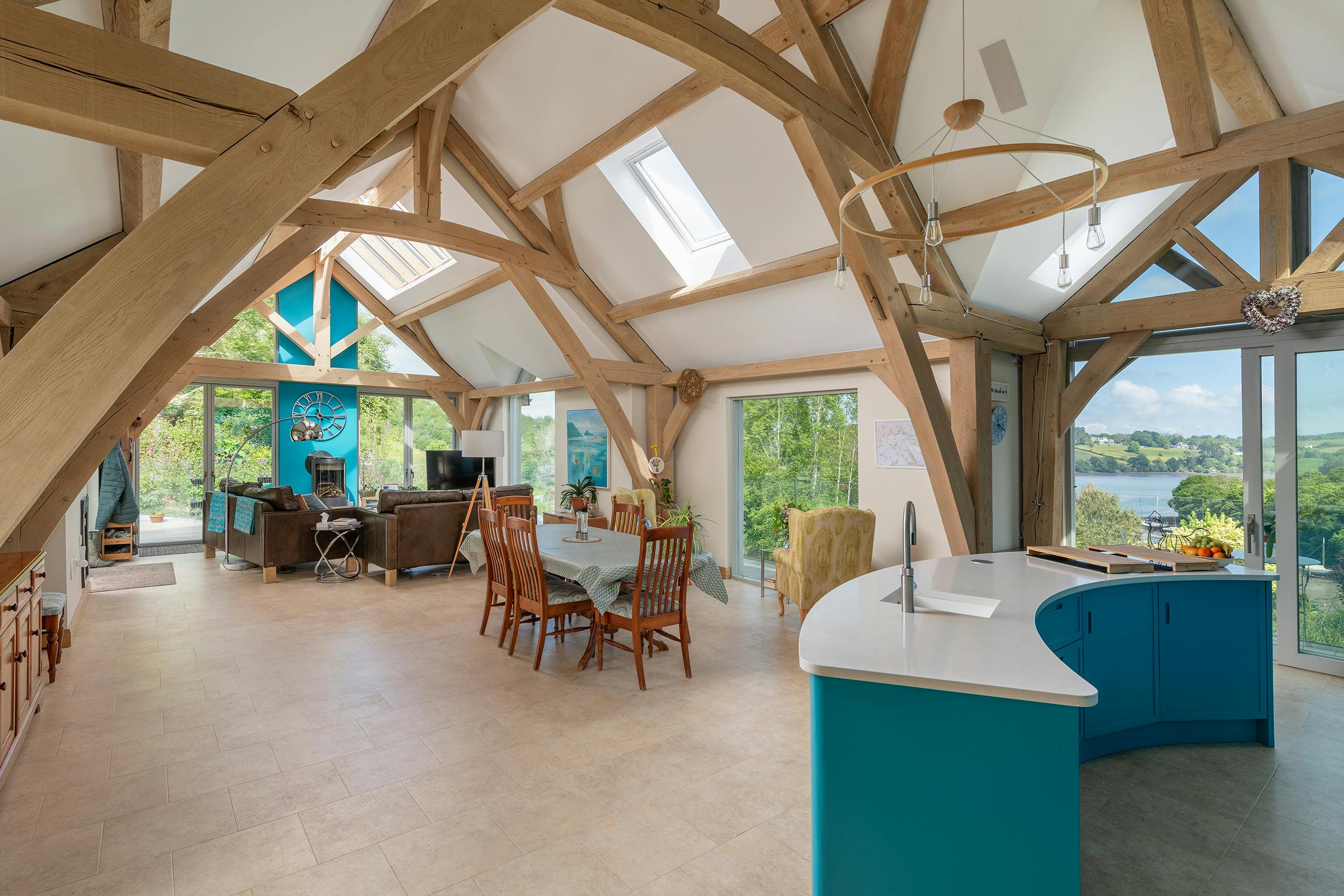 A vaulted ceiling in an oak framed open plan kitchen, dining room and living room with views of the estuary