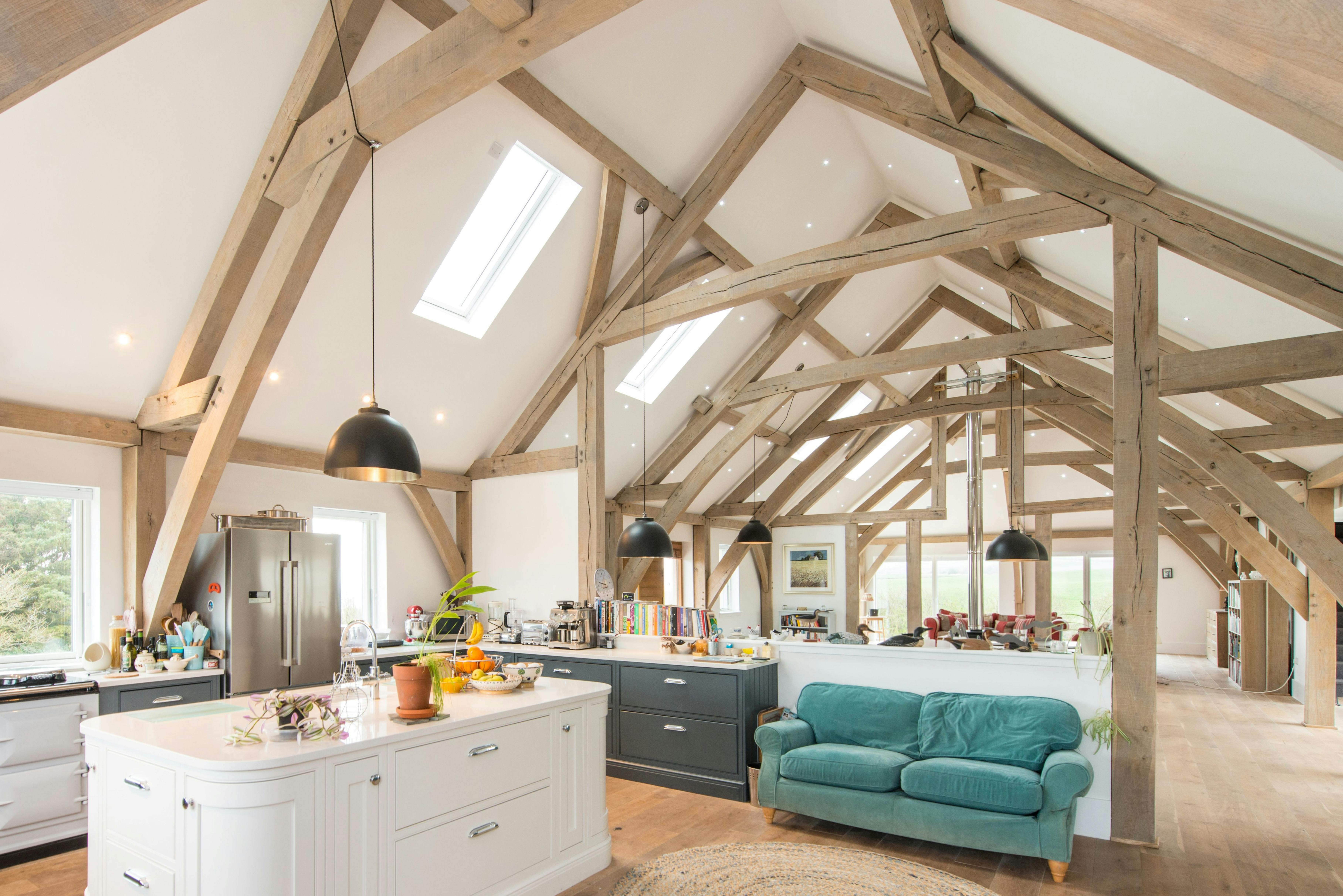 A vaulted oak framed open plan kitchen and living room with a white painted island
