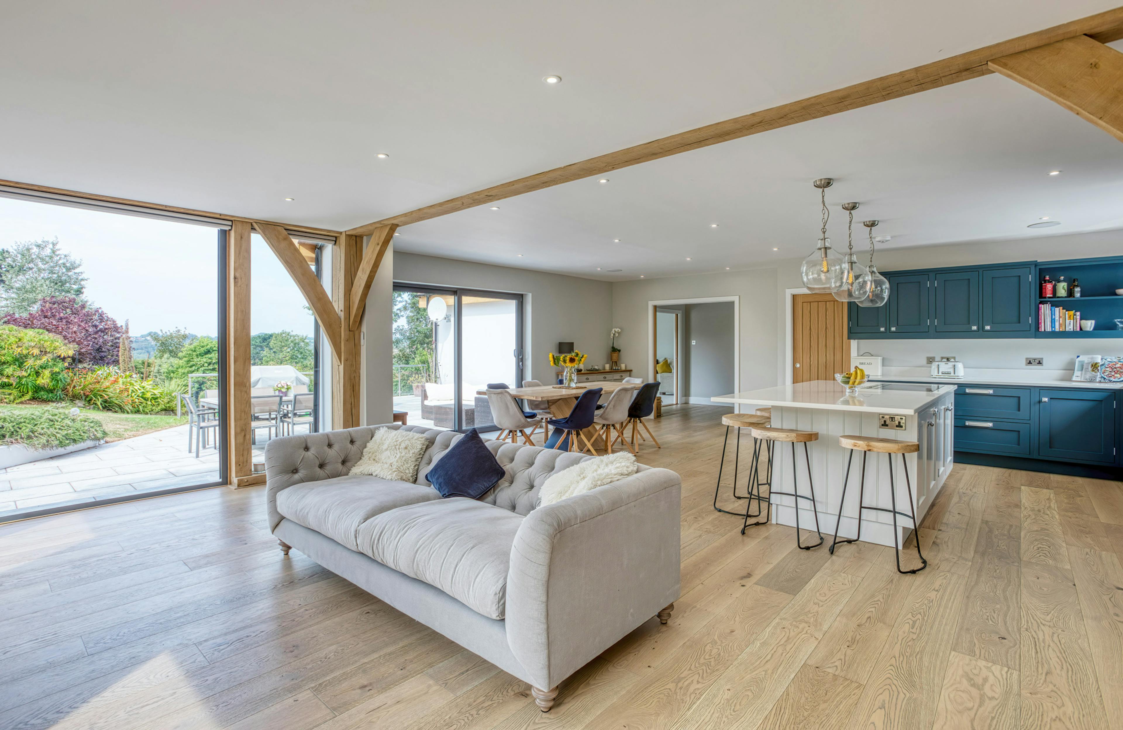 Interior view of an open-plan oak-framed extension with sitting, dining and kitchen areas