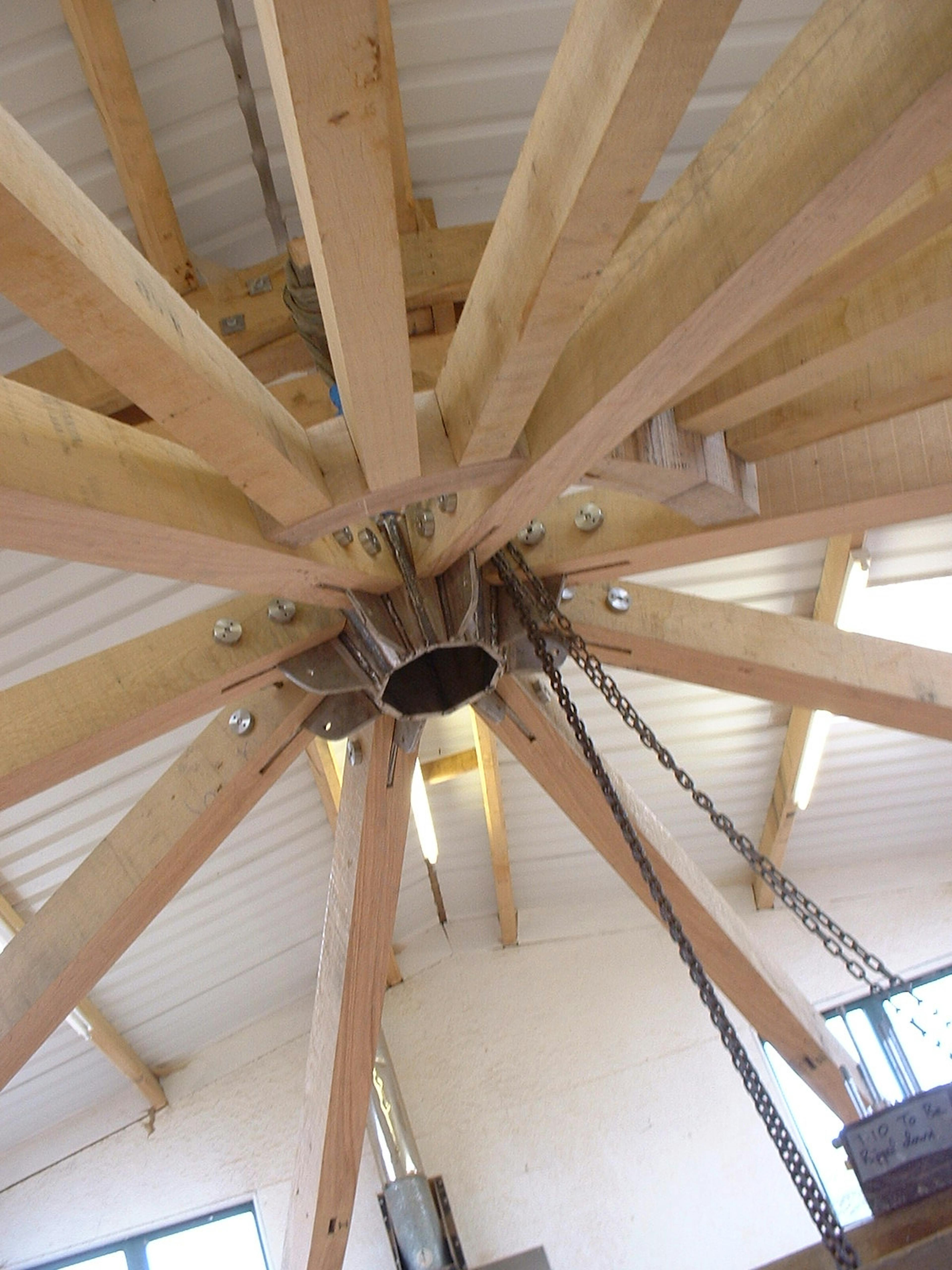 Timber roof structure assembly in a workshop, showing exposed beams and framework during construction