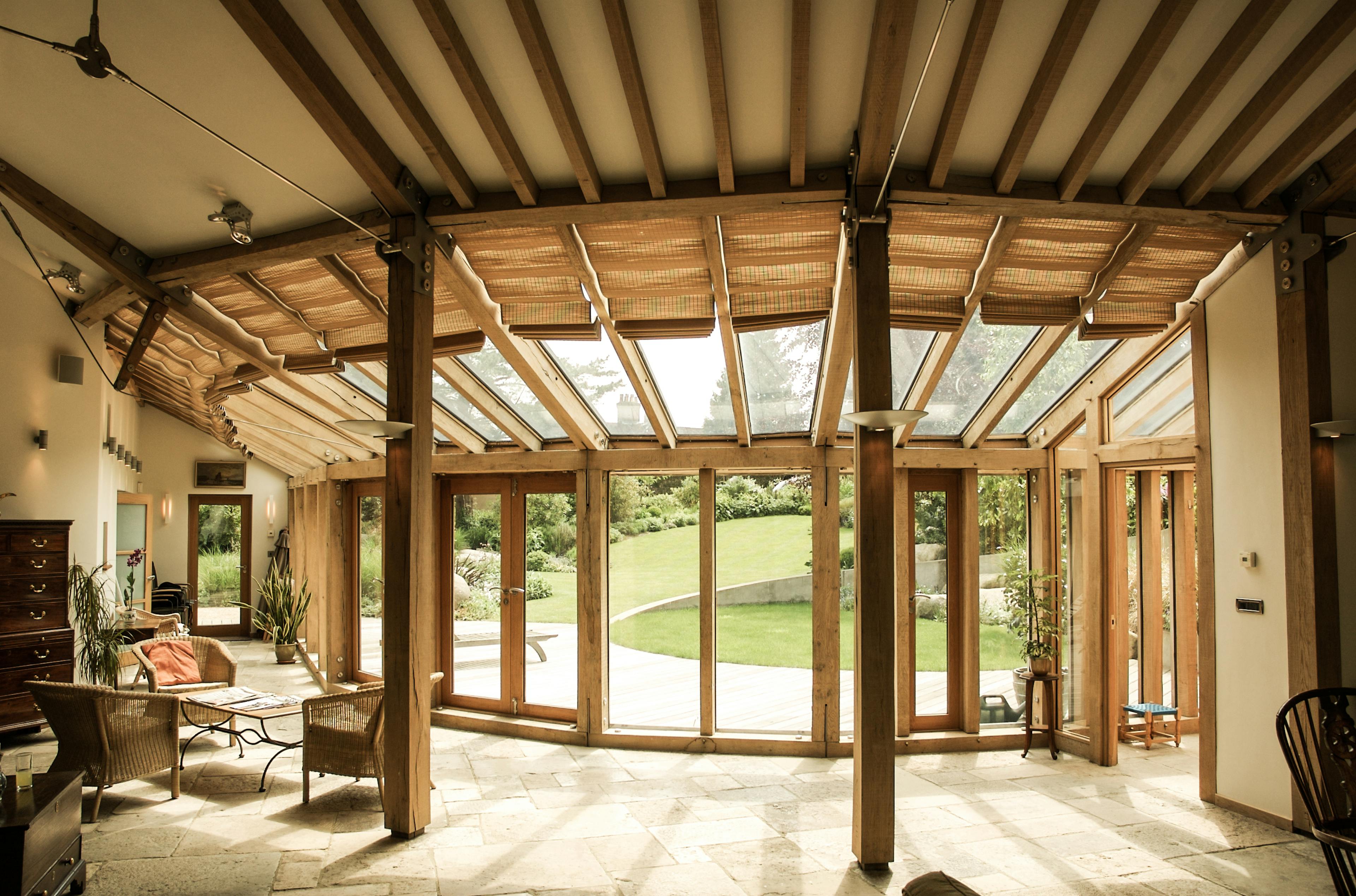 Close-up of interior glazing detail in an oak-framed house, showing the connection between large glass panels and timber framing, highlighting craftsmanship and material contrast