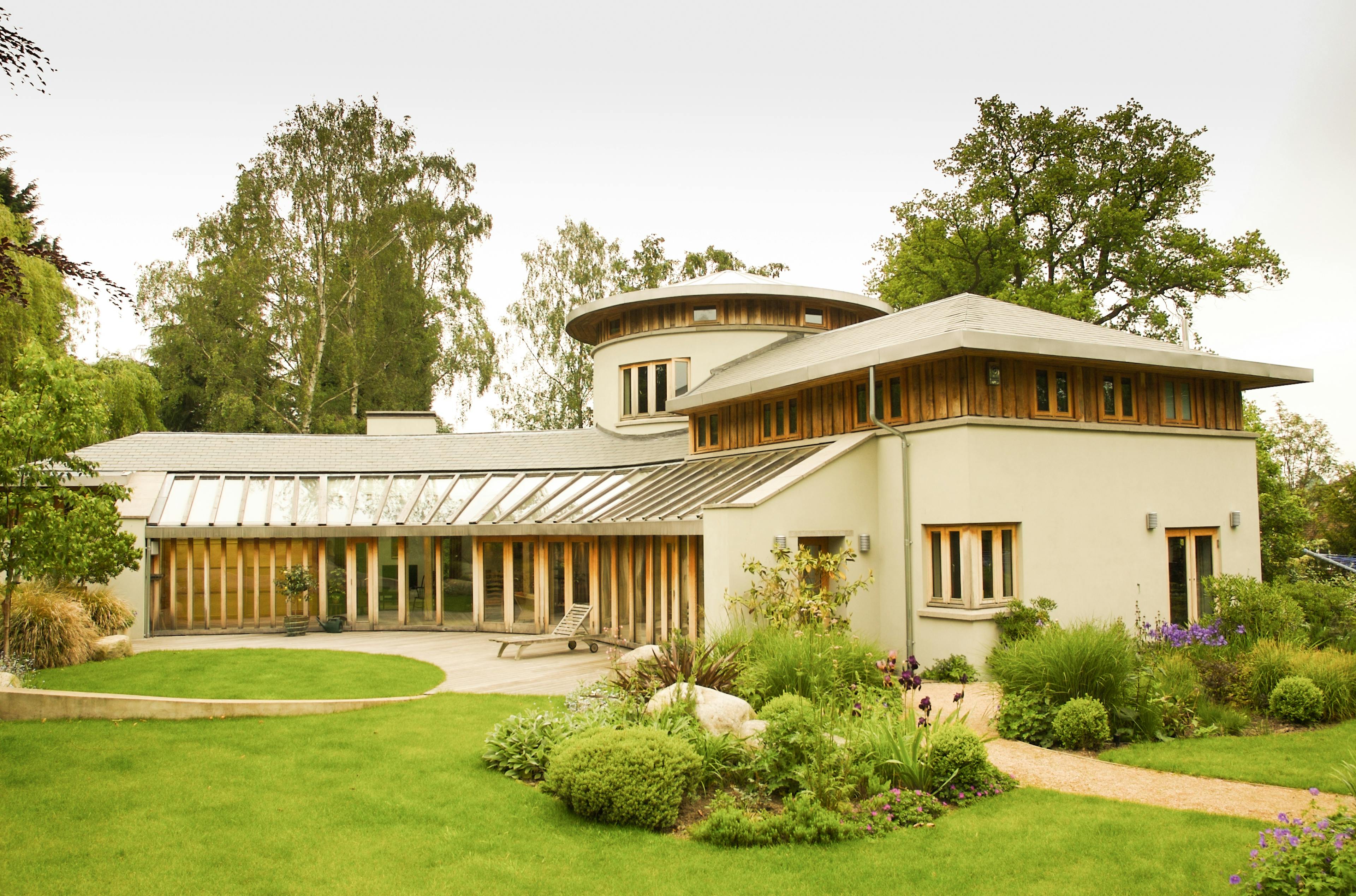Exterior view of a curved oak timber frame structure showcasing smooth, flowing lines and natural wood textures integrated into the building design