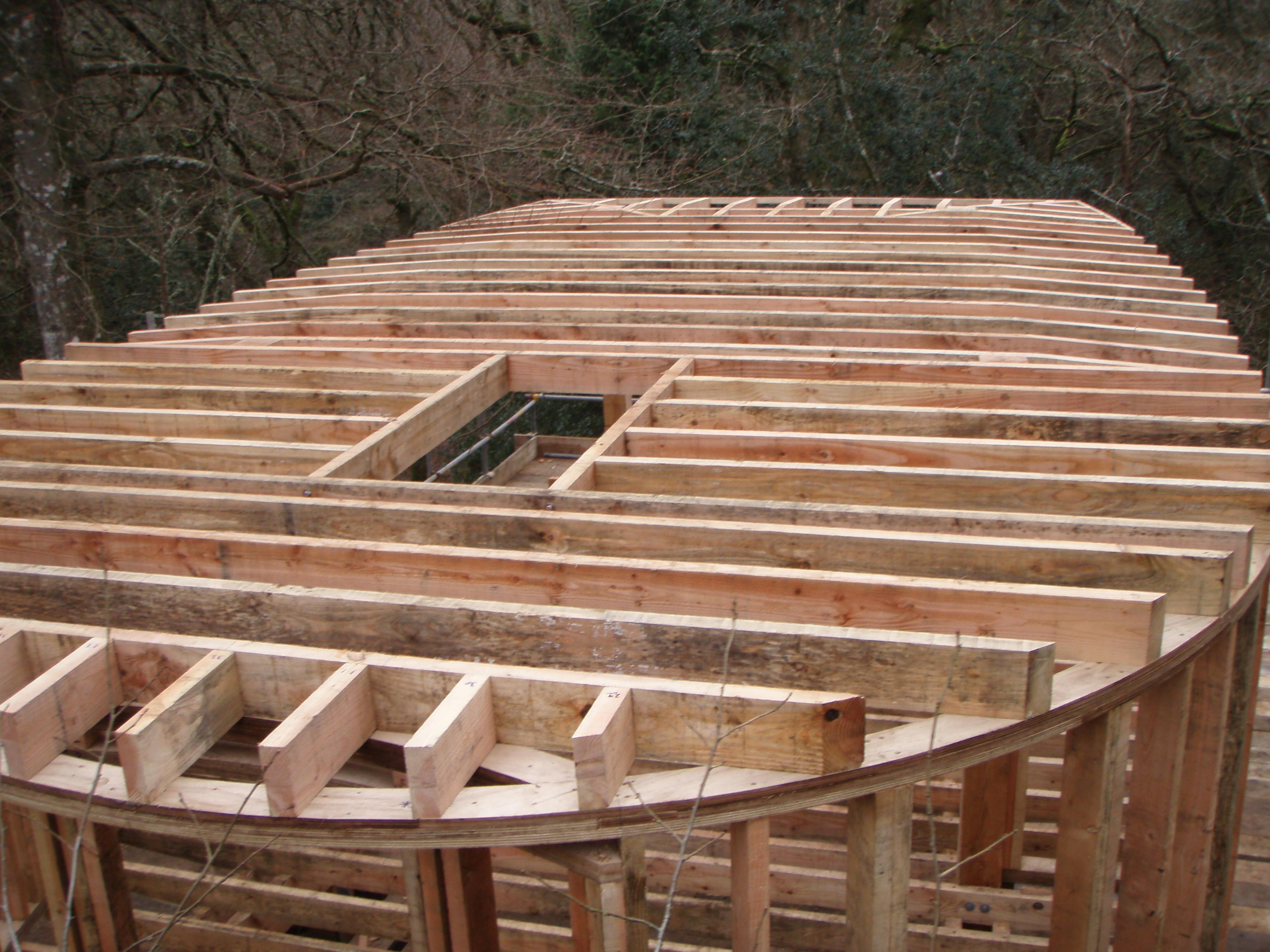 Close-up of Douglas fir timber beams being assembled to form the roof structure of a treehouse at a Dartmoor construction site