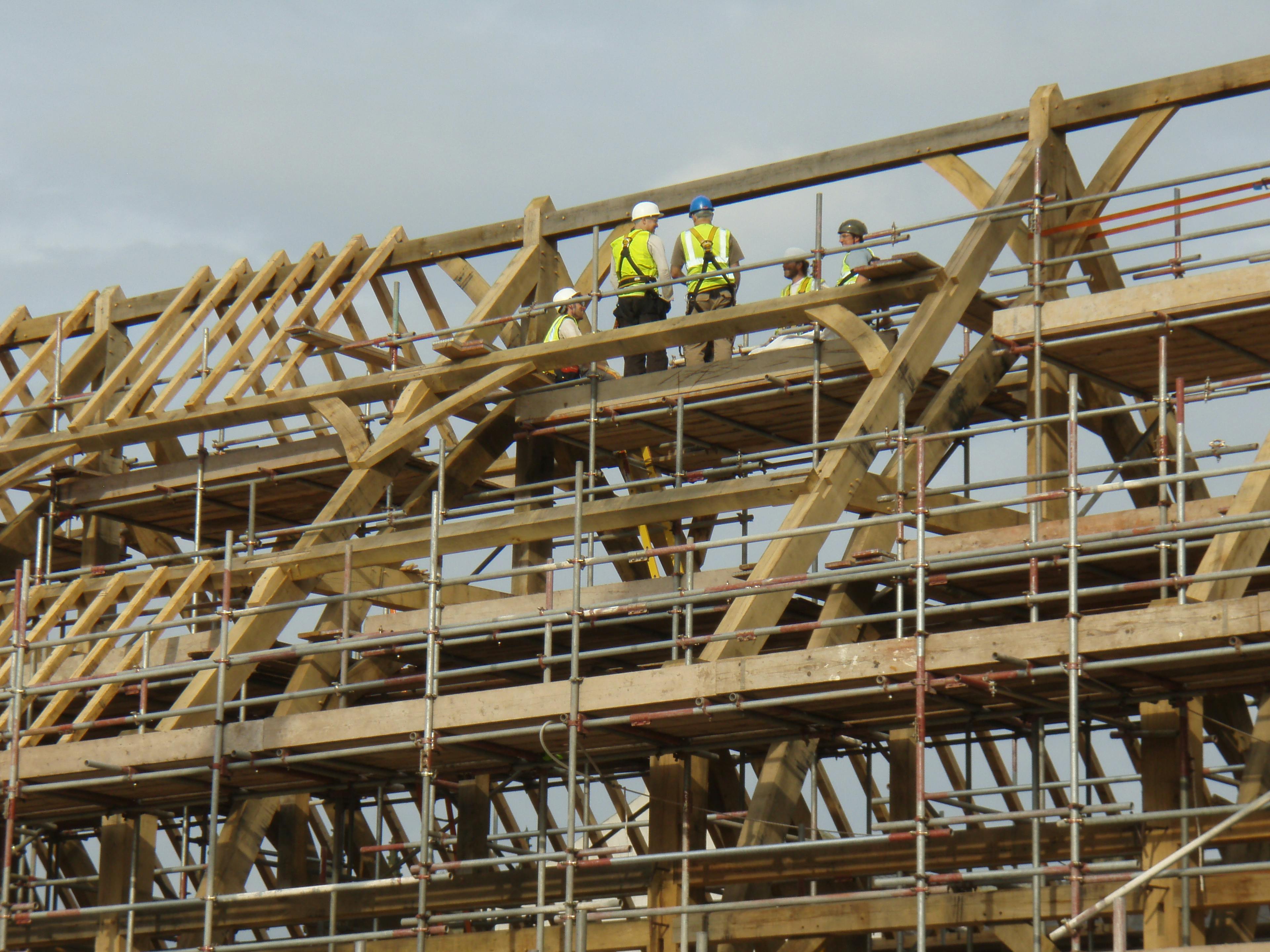 Construction team assembling an oak frame on site for the Penistone Market project, with visible timber structure and collaborative work in progress