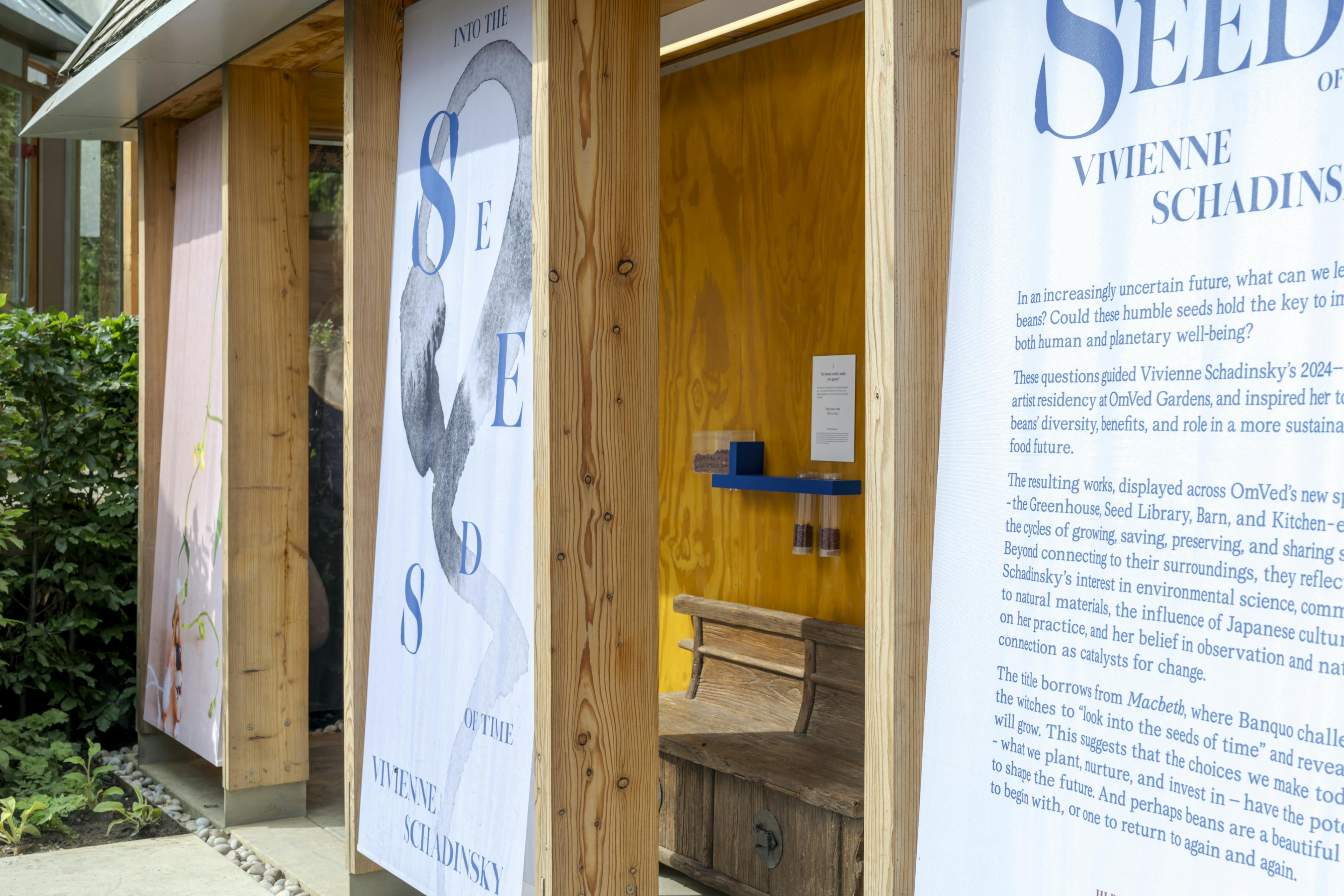 Exterior view of a timber-framed structure made from Douglas fir, with event banners displayed along the façade, set in a landscaped outdoor area