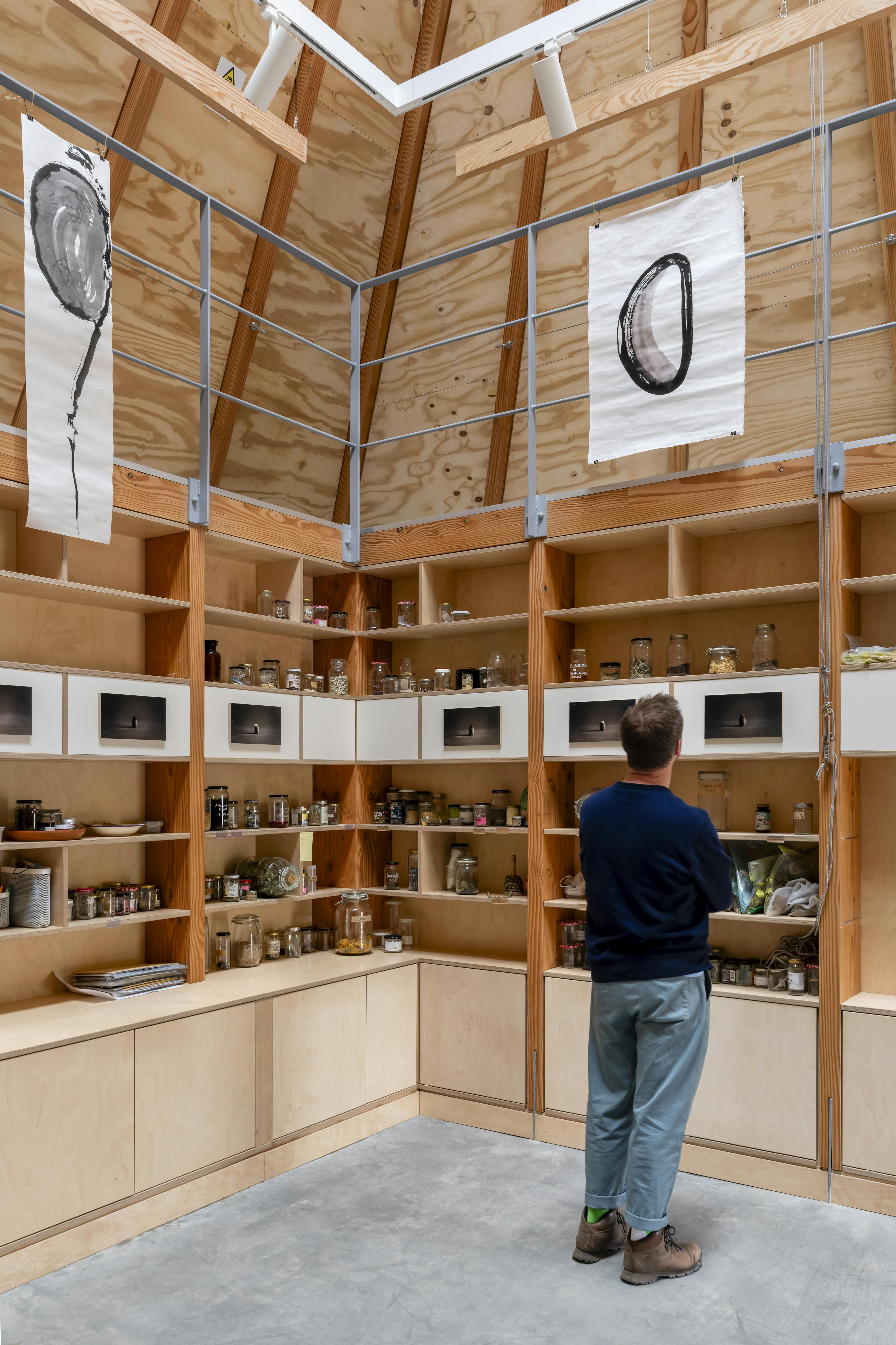 Interior of a Douglas fir-framed event space arranged for the Seed Vault exhibition, with display panels and warm natural lighting highlighting the timber structure
