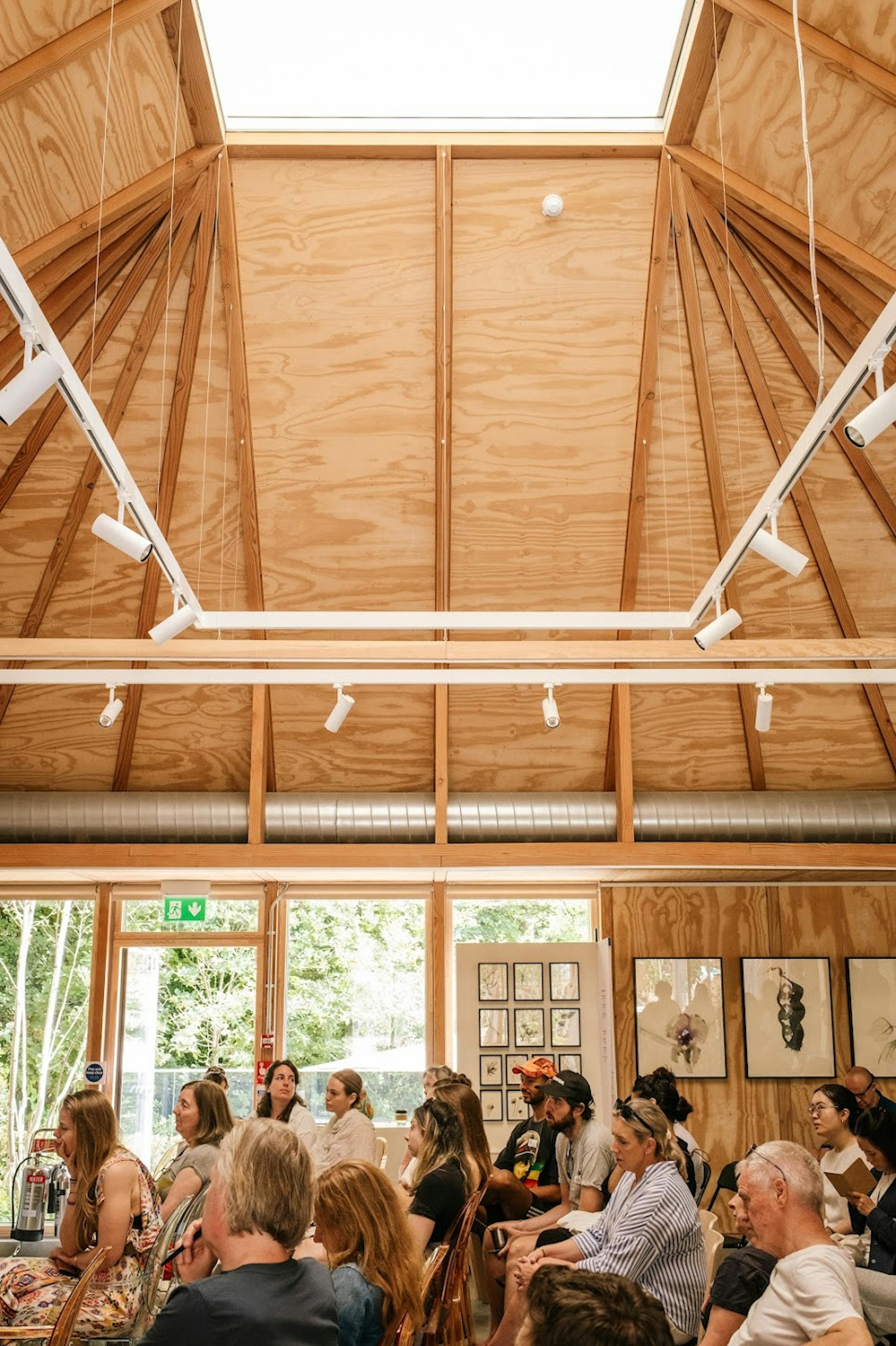 Interior of a workshop venue with Douglas fir roof structure featuring exposed timber beams and natural lighting