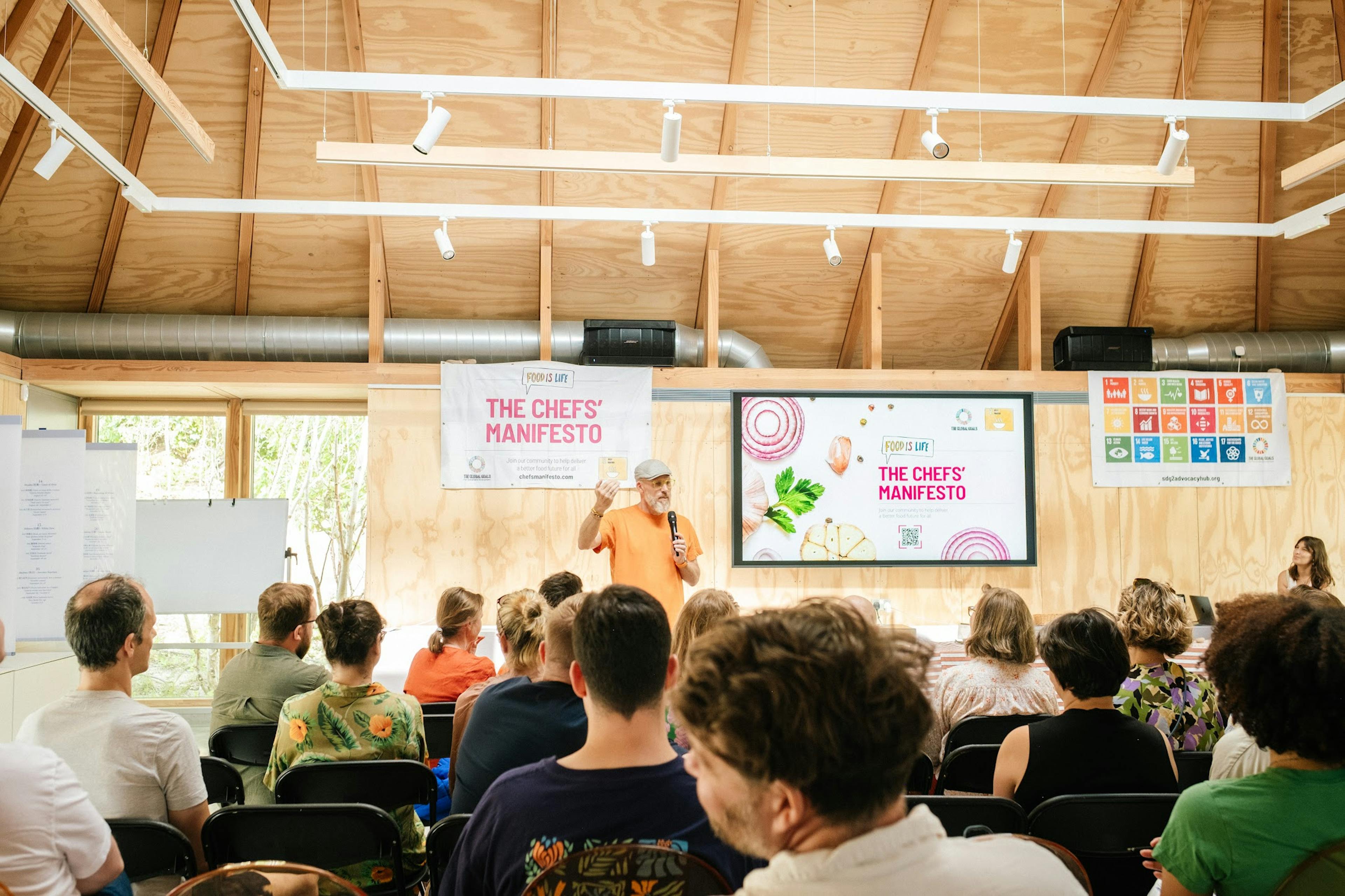 Interior of a workshop venue with Douglas fir timber framing, set up for a presentation during an event