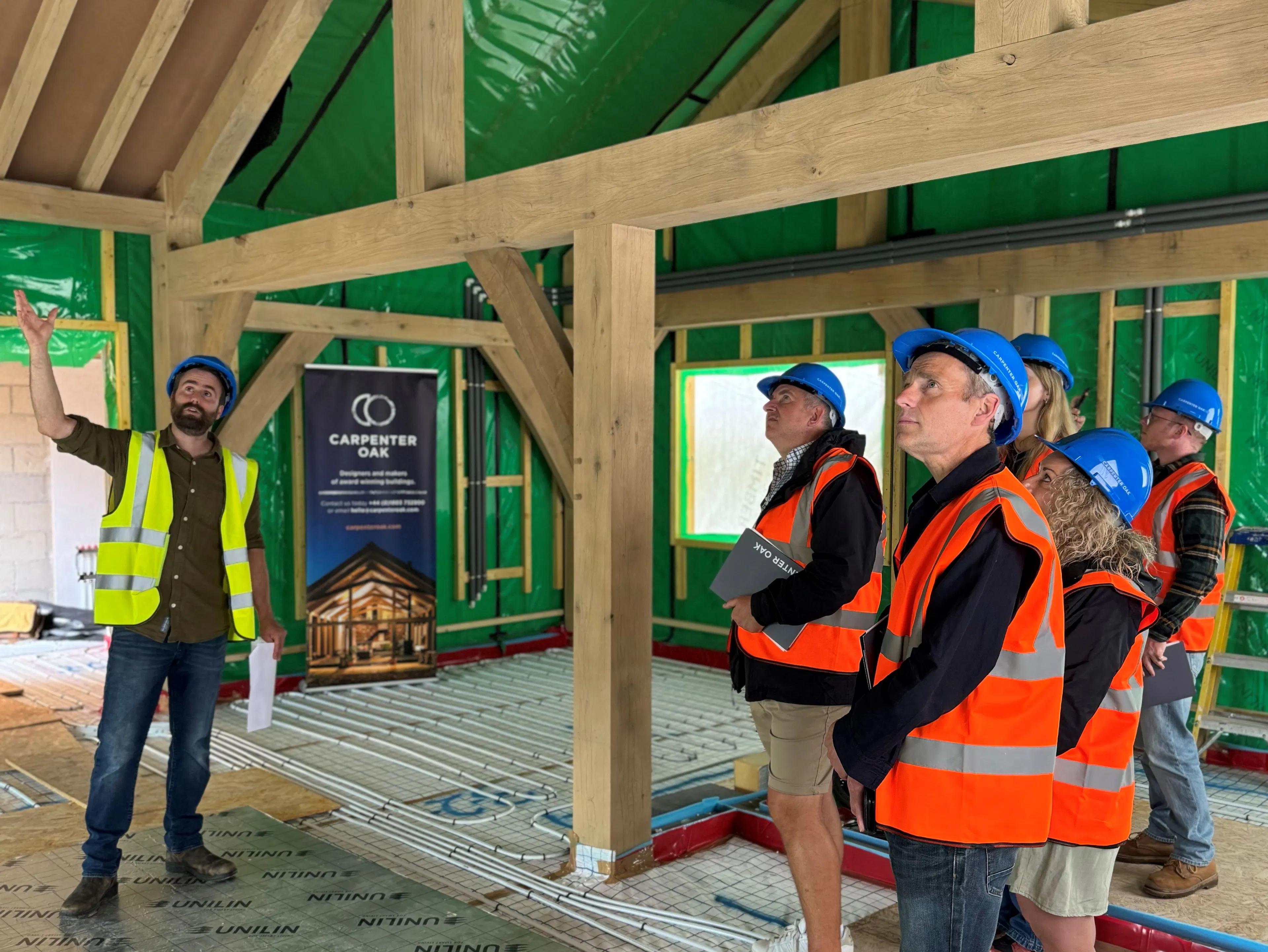People on a tour of an oak frame during the construction phase