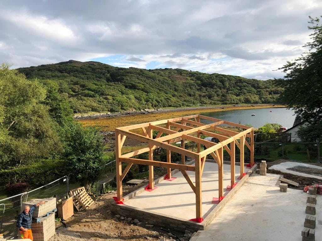 A Douglas fir frame home on the shoreline of a Scottish coast during construction