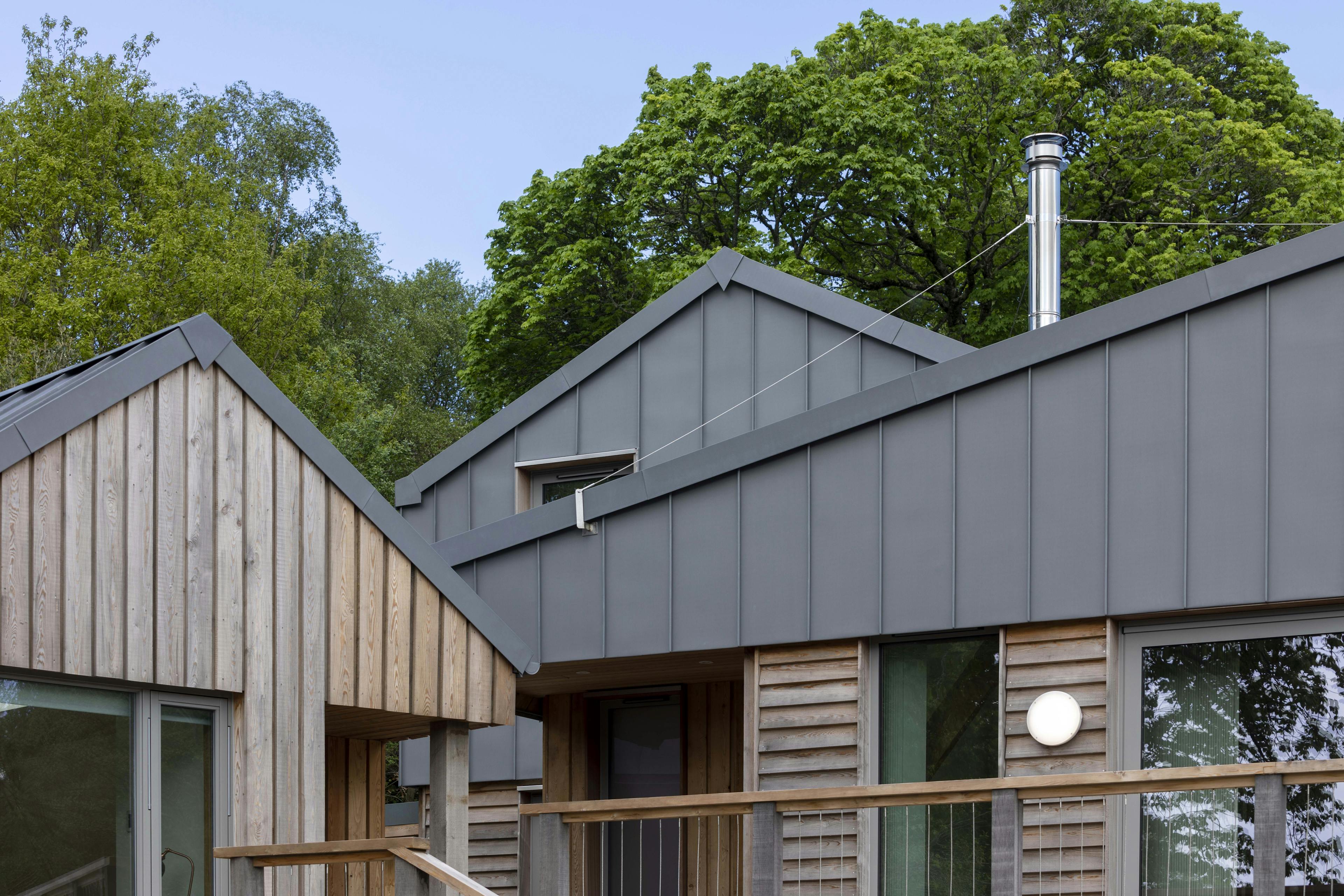 A new home built with a zinc roof and larch cladding