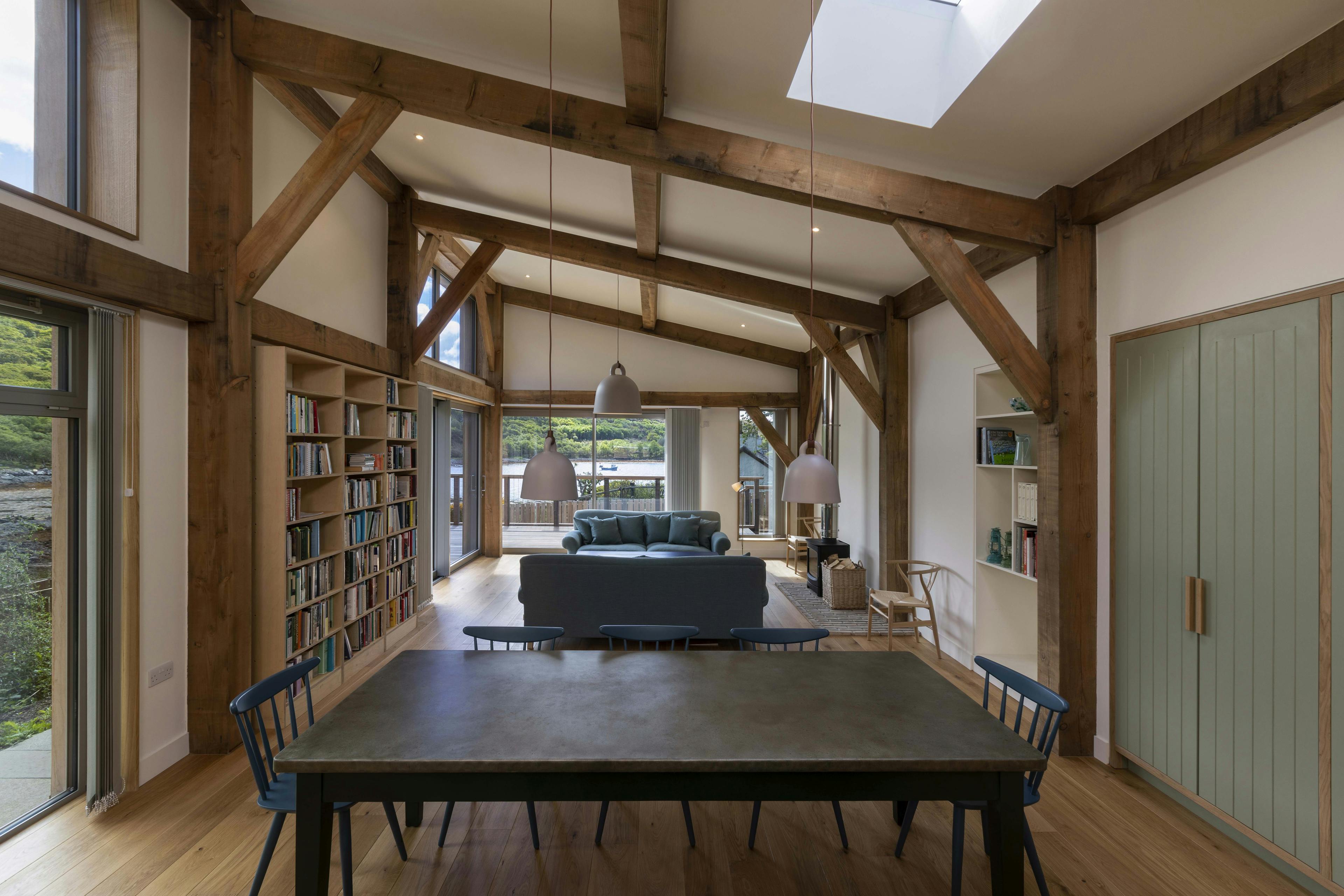 An open plan living and dining room with a Douglas fir framed mono pitched roof