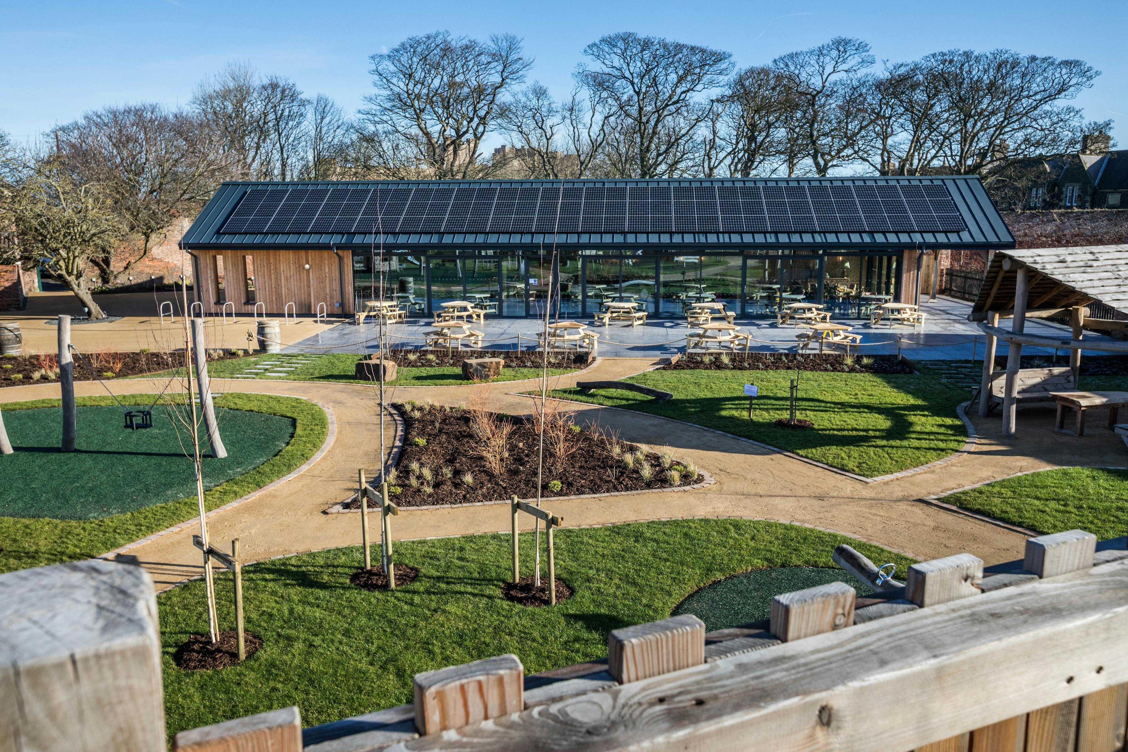 The garden of an oak framed cafe with solar panels on the roof
