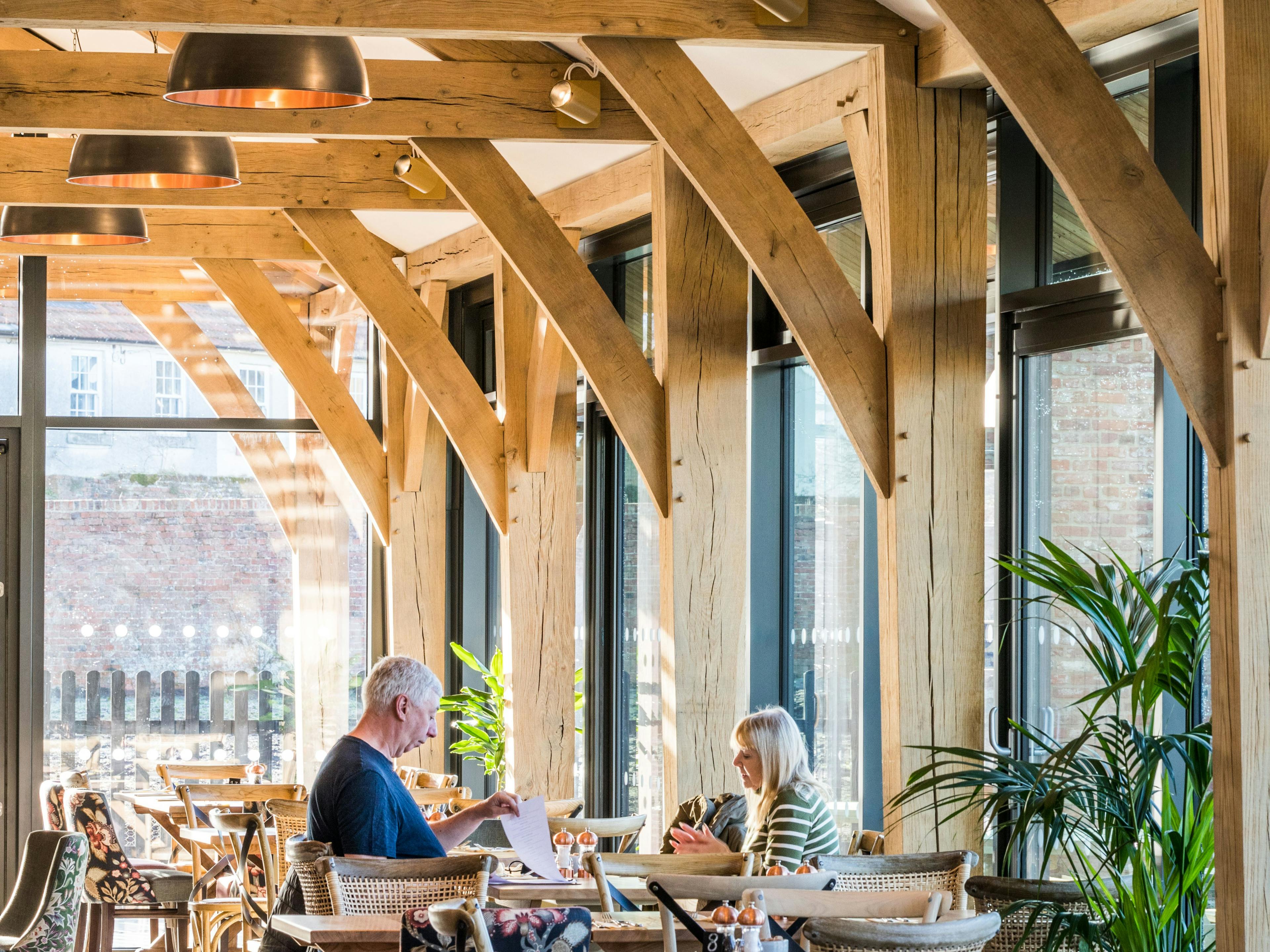 Internal image of an oak framed cafe with customers sat at a table