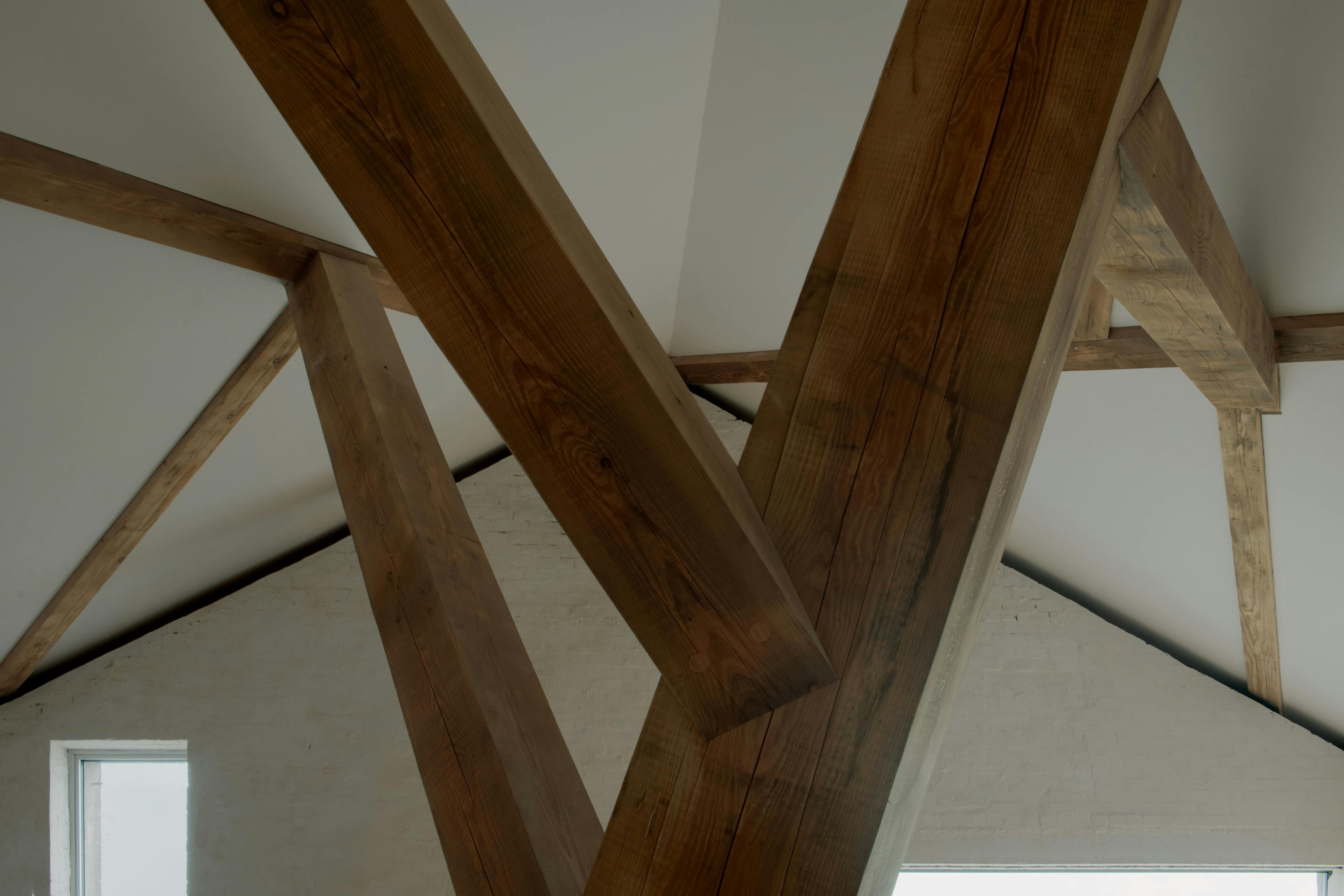 Interior of a riverside boathouse with a complex structural timber frame