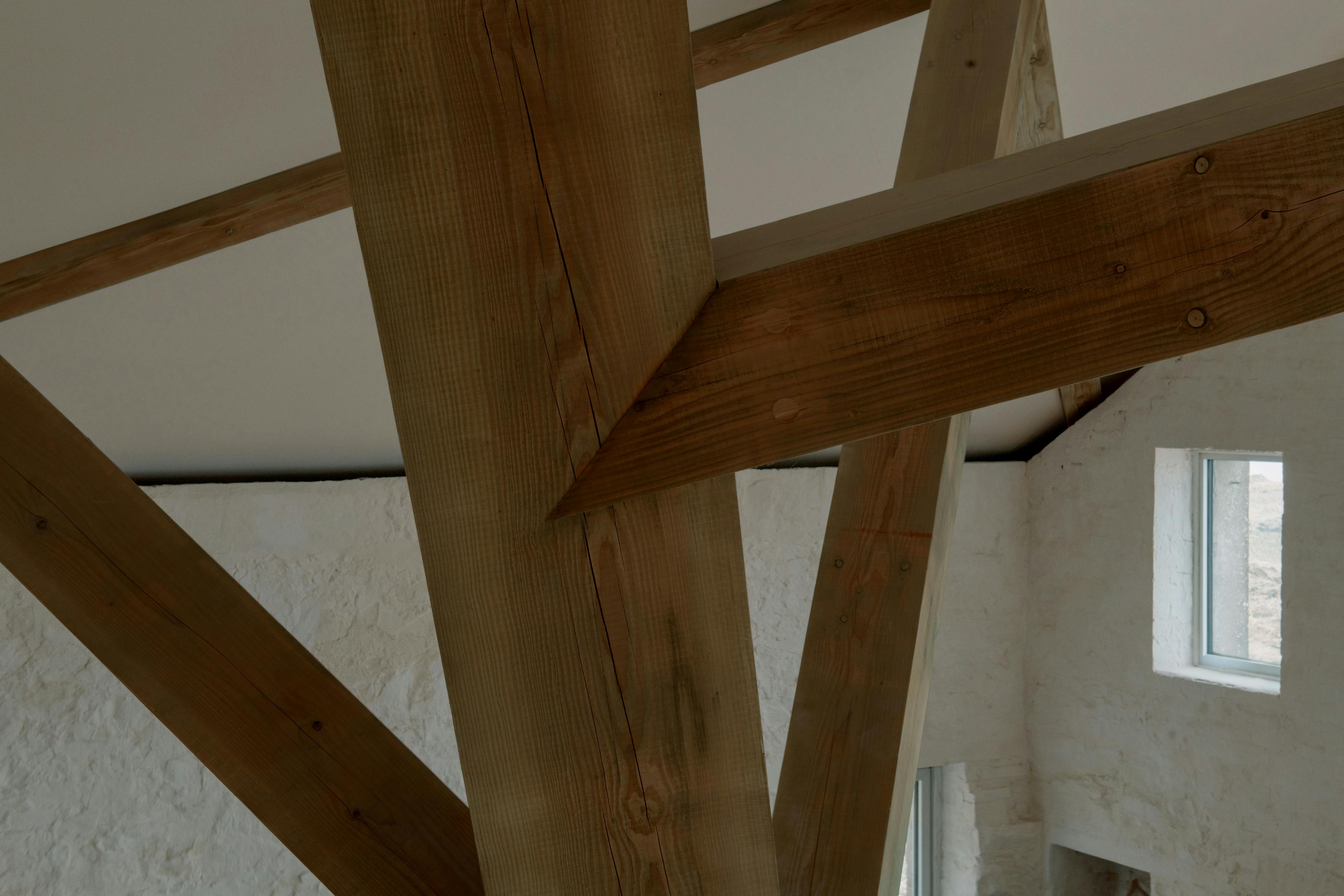 Interior of a riverside boathouse with a complex structural timber frame