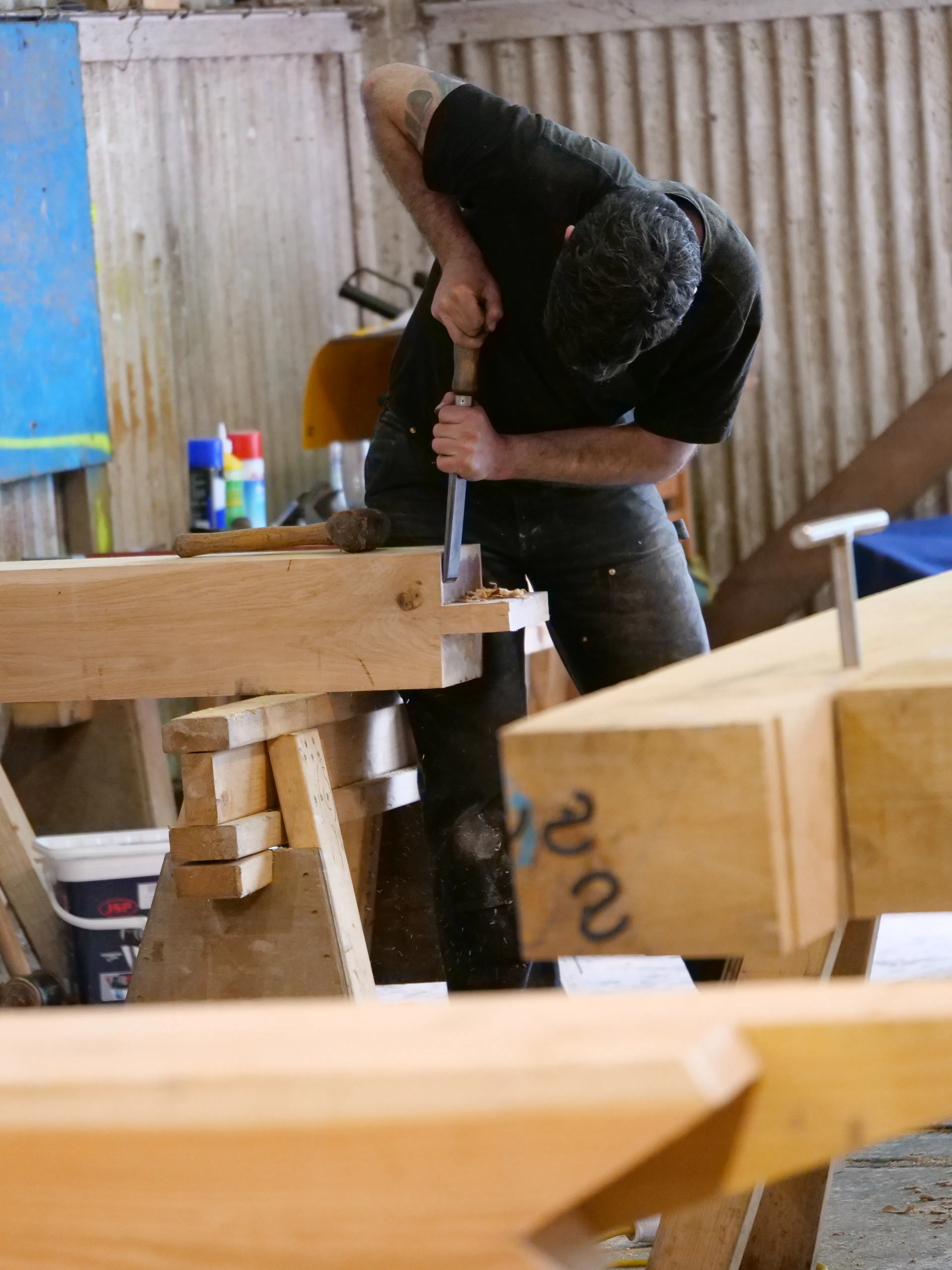 Carpenters in the workshop cutting a frame for the Riverside Boathouse, using Douglas fir and larch timbers