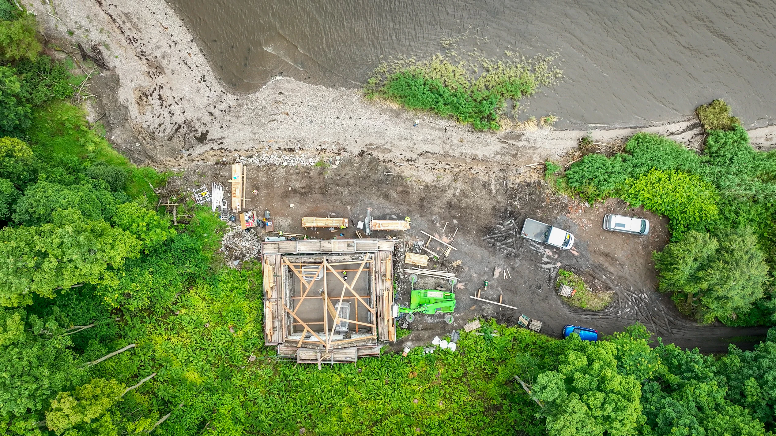 Aerial view of the Riverside Boathouse under construction on site, showing installation of Douglas fir and larch timbers