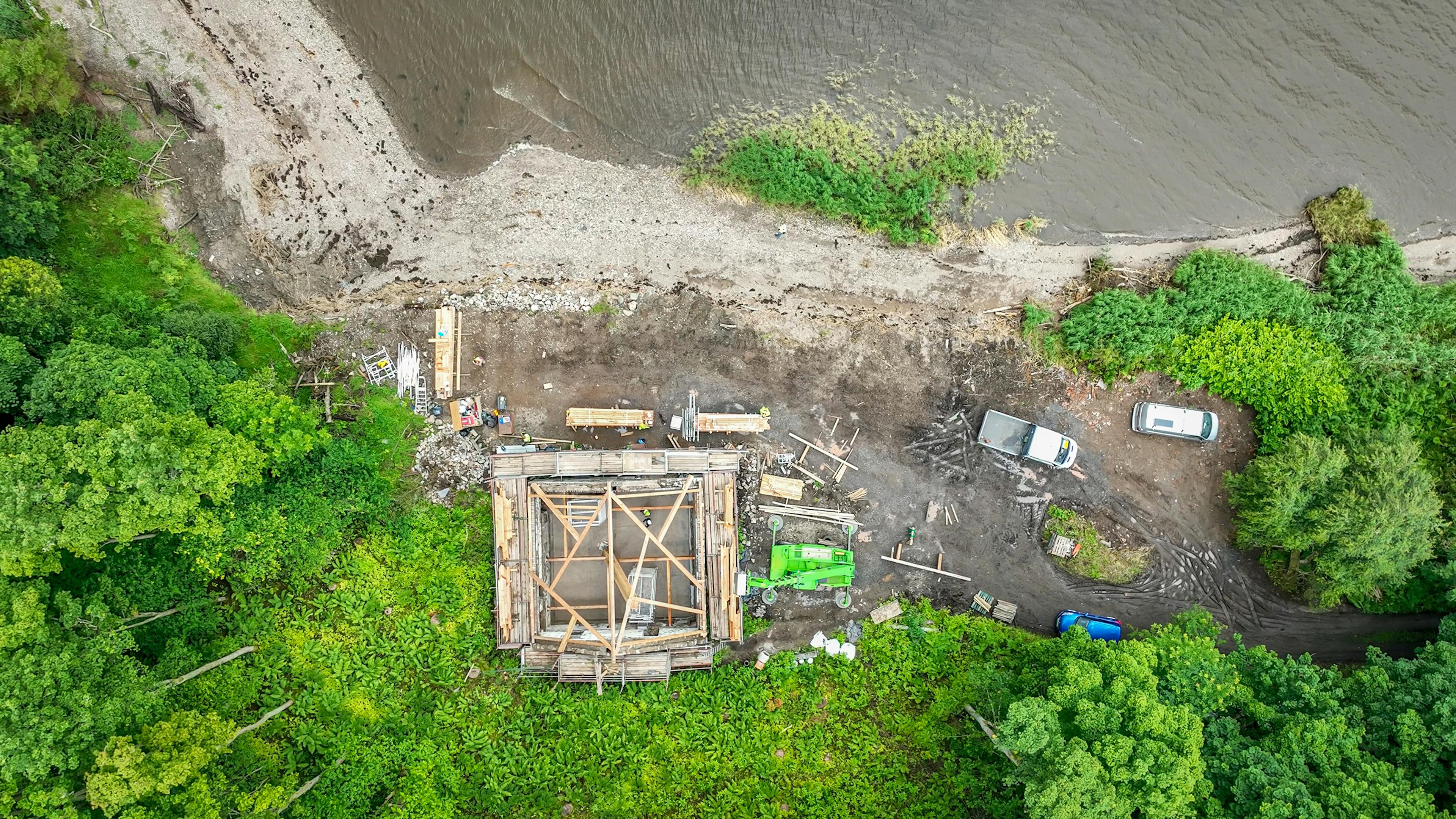 Aerial view of the Riverside Boathouse under construction on site, showing installation of Douglas fir and larch timbers