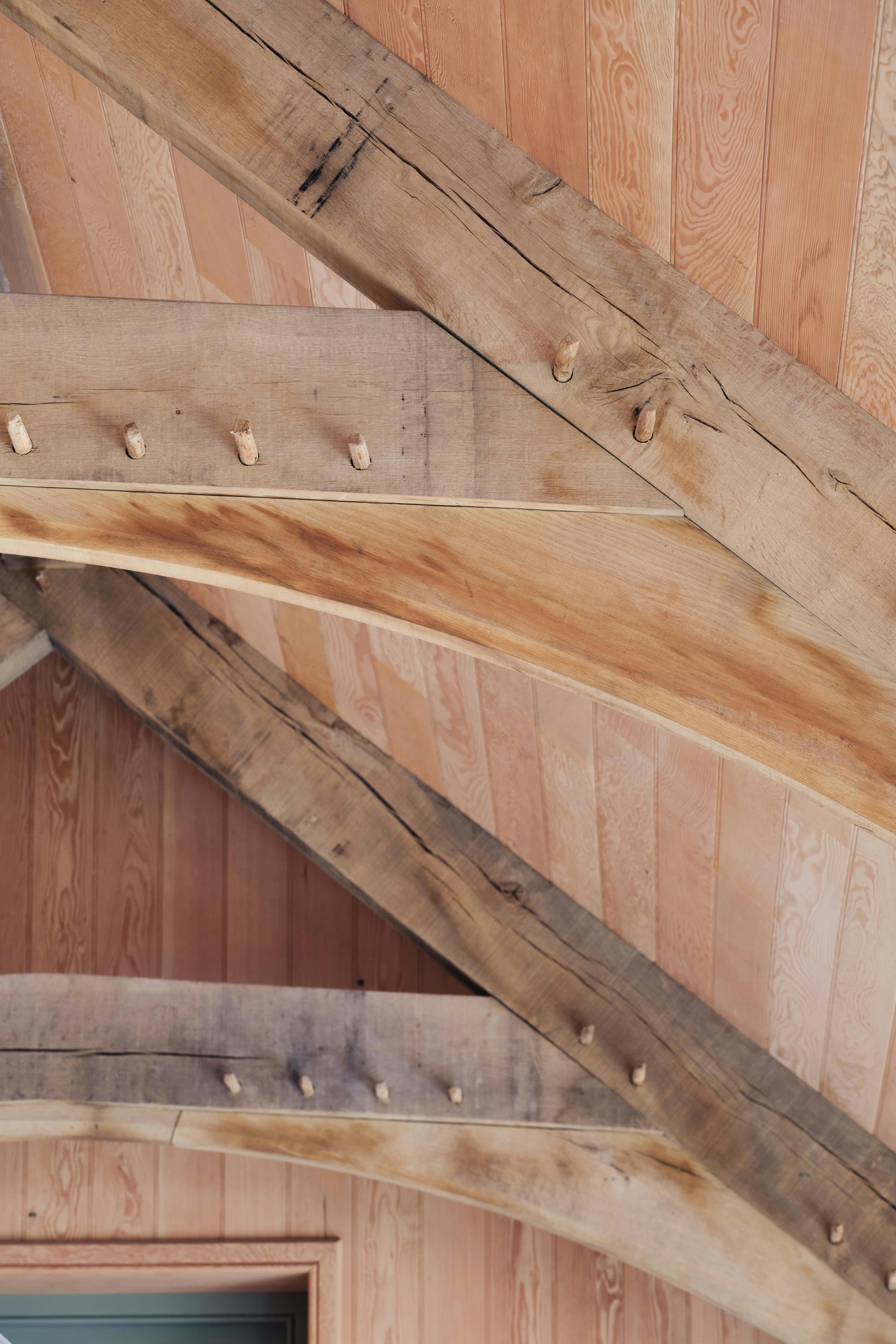 Close-up of an oak truss showcasing intricate joinery and pegged connections