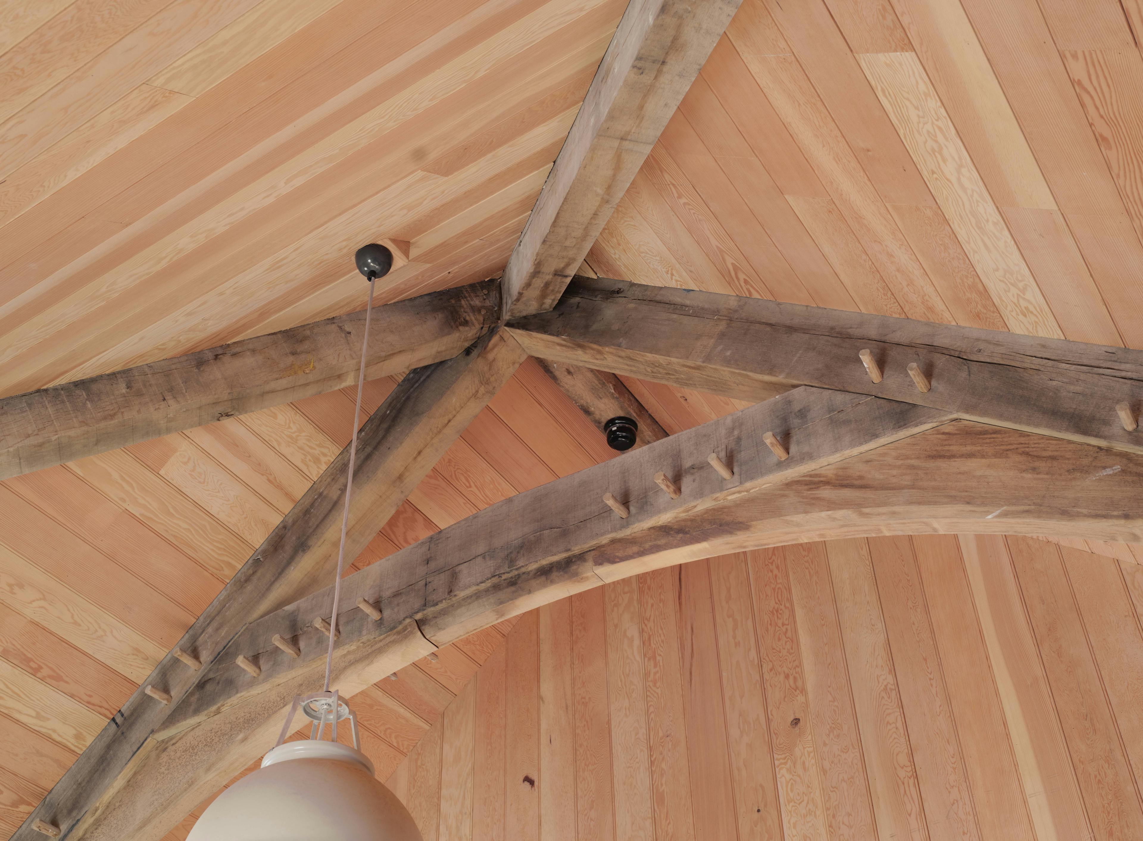 Detailed oak truss joinery inside Home Farm barns on Aldourie Estate, complemented by Douglas fir cladding