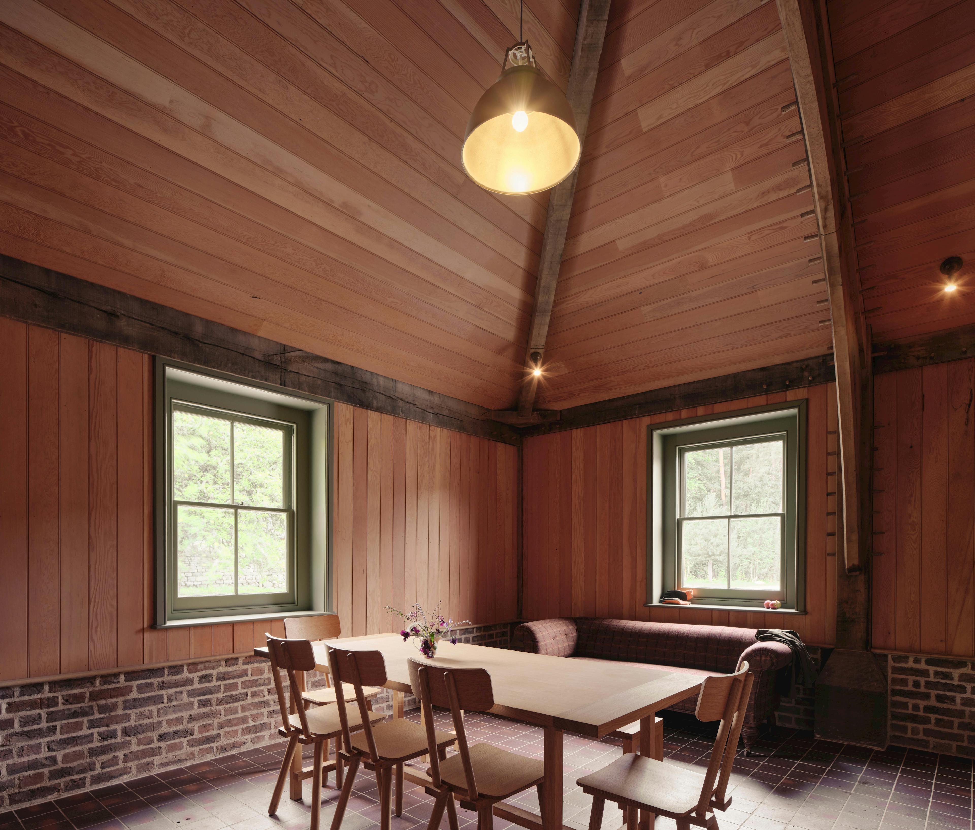 Interior of a traditional oak-framed barn featuring a minimalist kitchen layout