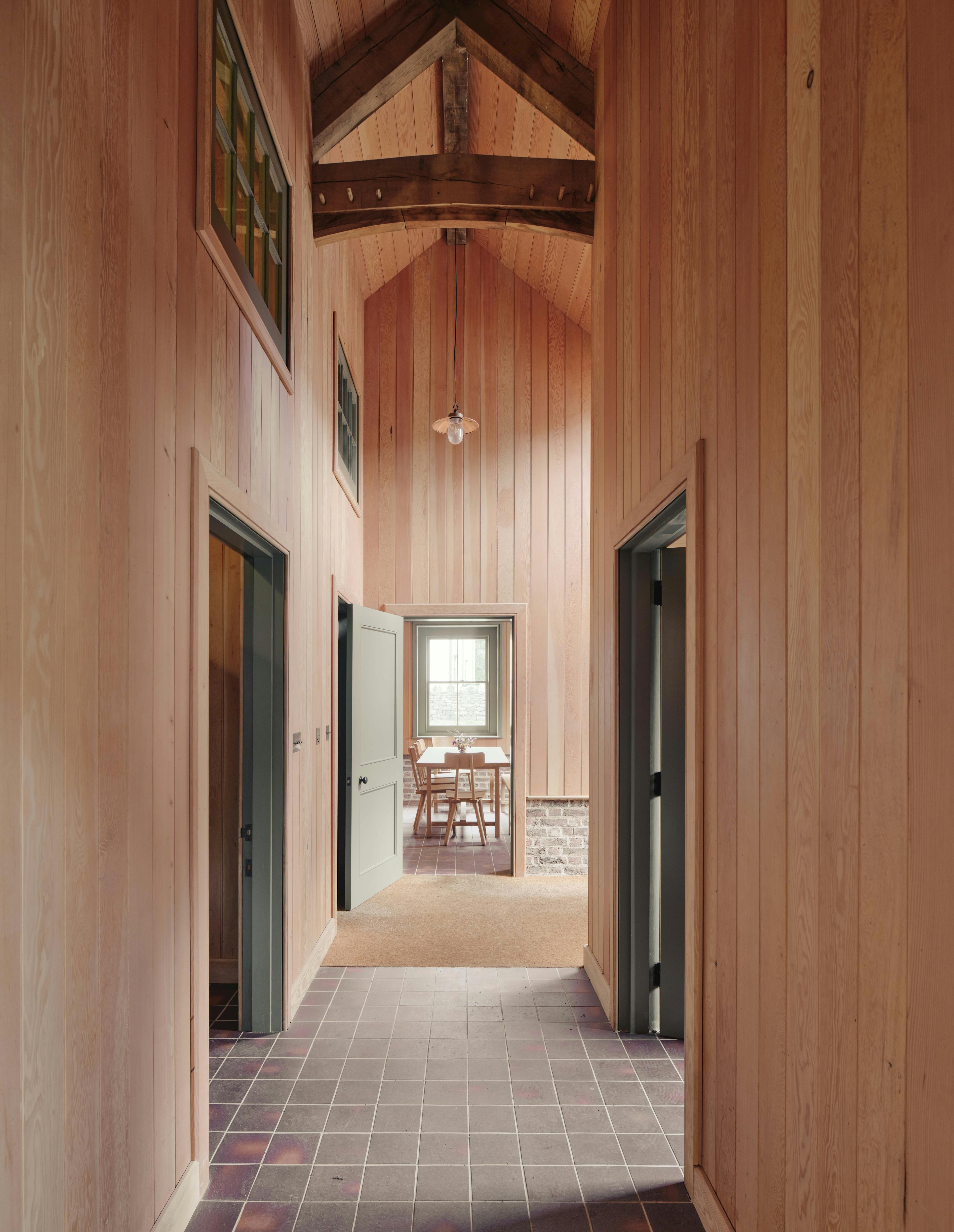 Interior hallway of timber-framed Home Farm barns at Aldourie Estate, showcasing traditional construction