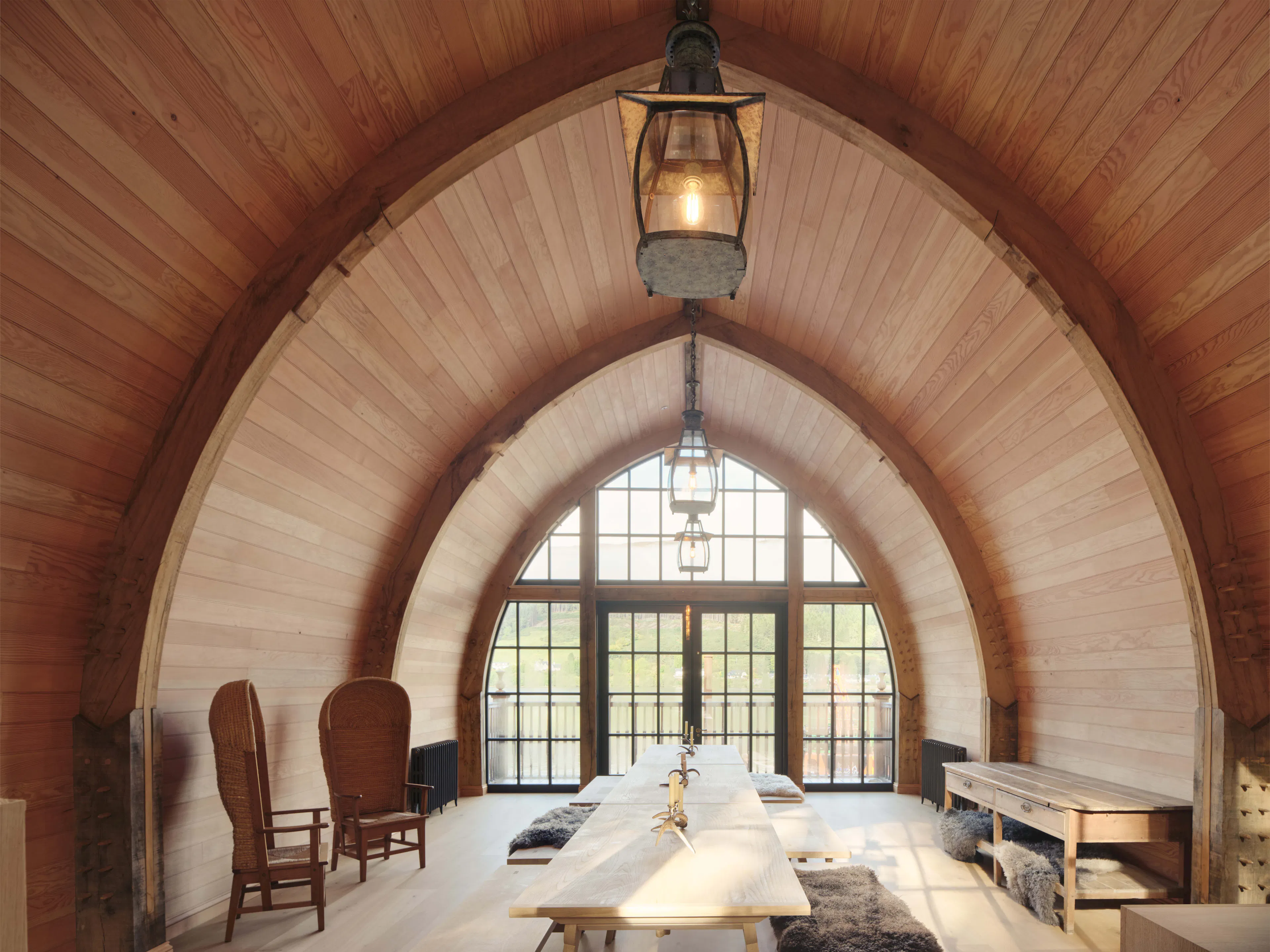 Inside a traditional oak-framed boathouse, showcasing Douglas fir cladding and a glazed gable end