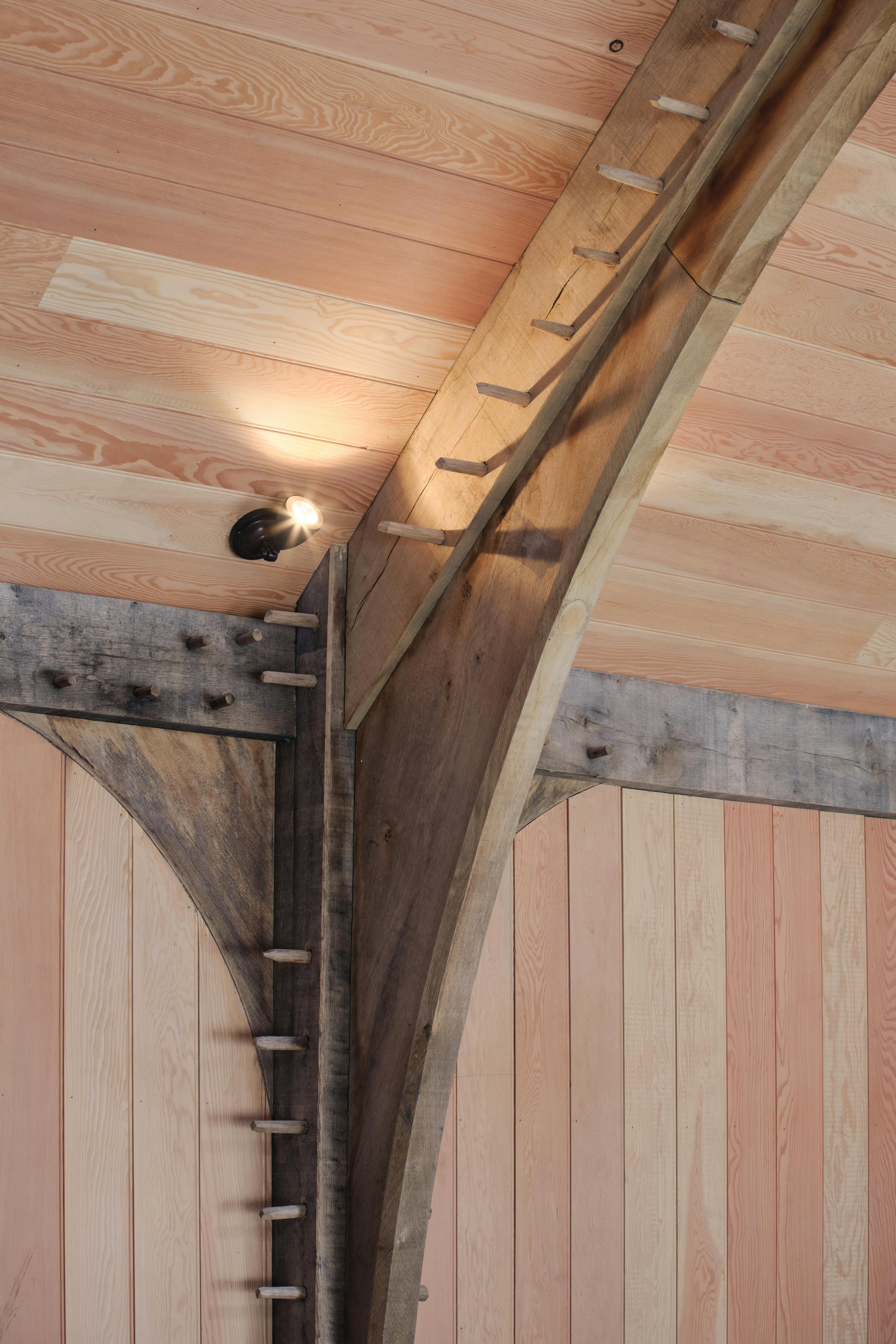 Finished oak frame trusses with Douglas fir cladding, wall brace, and peg details at the Home Farm Barns on the Aldourie Estate in Scotland
