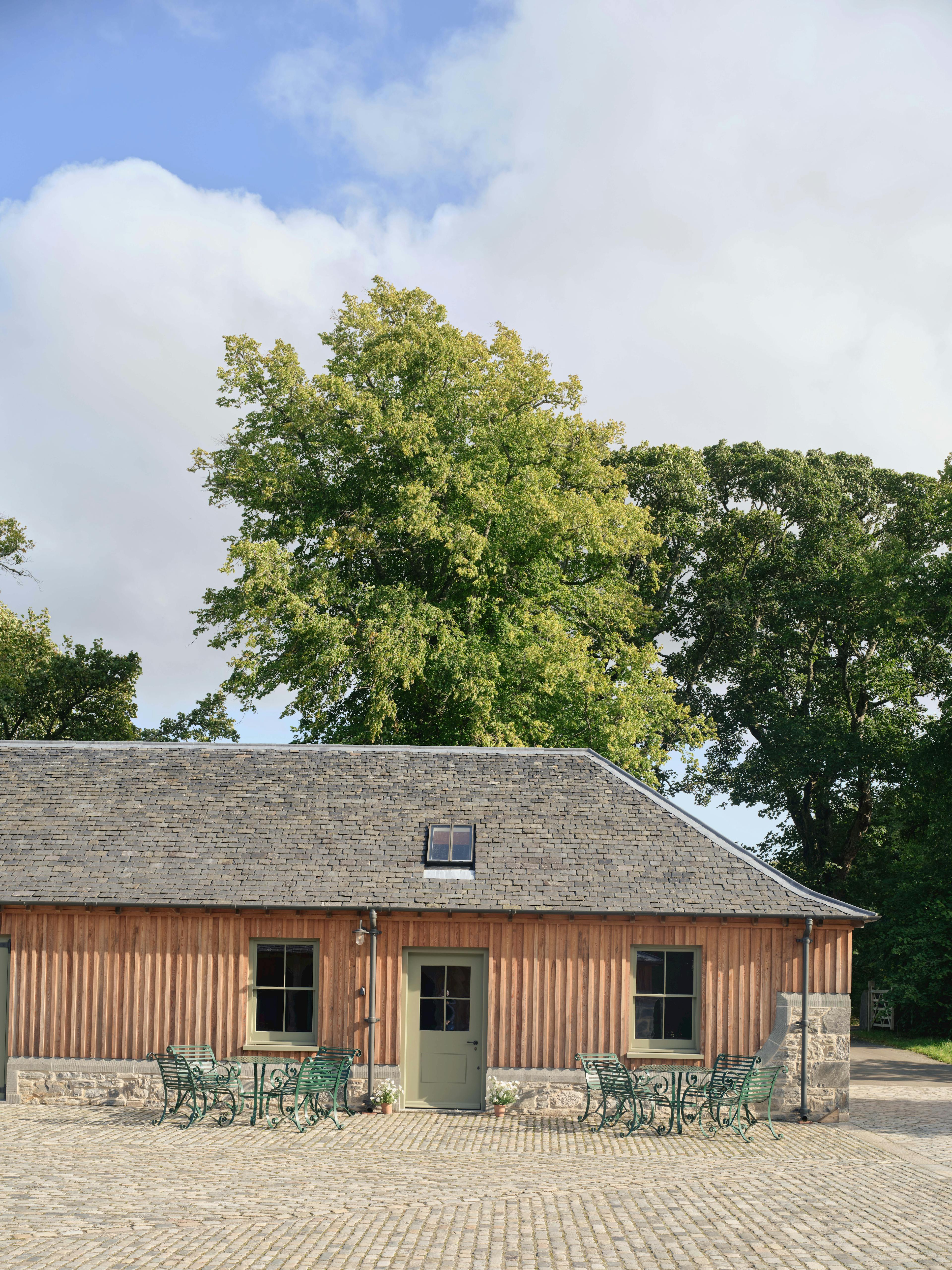 External view of the Home Farm Barns on the Aldourie Estate in Scotland featuring finished oak frame trusses with Douglas fir cladding