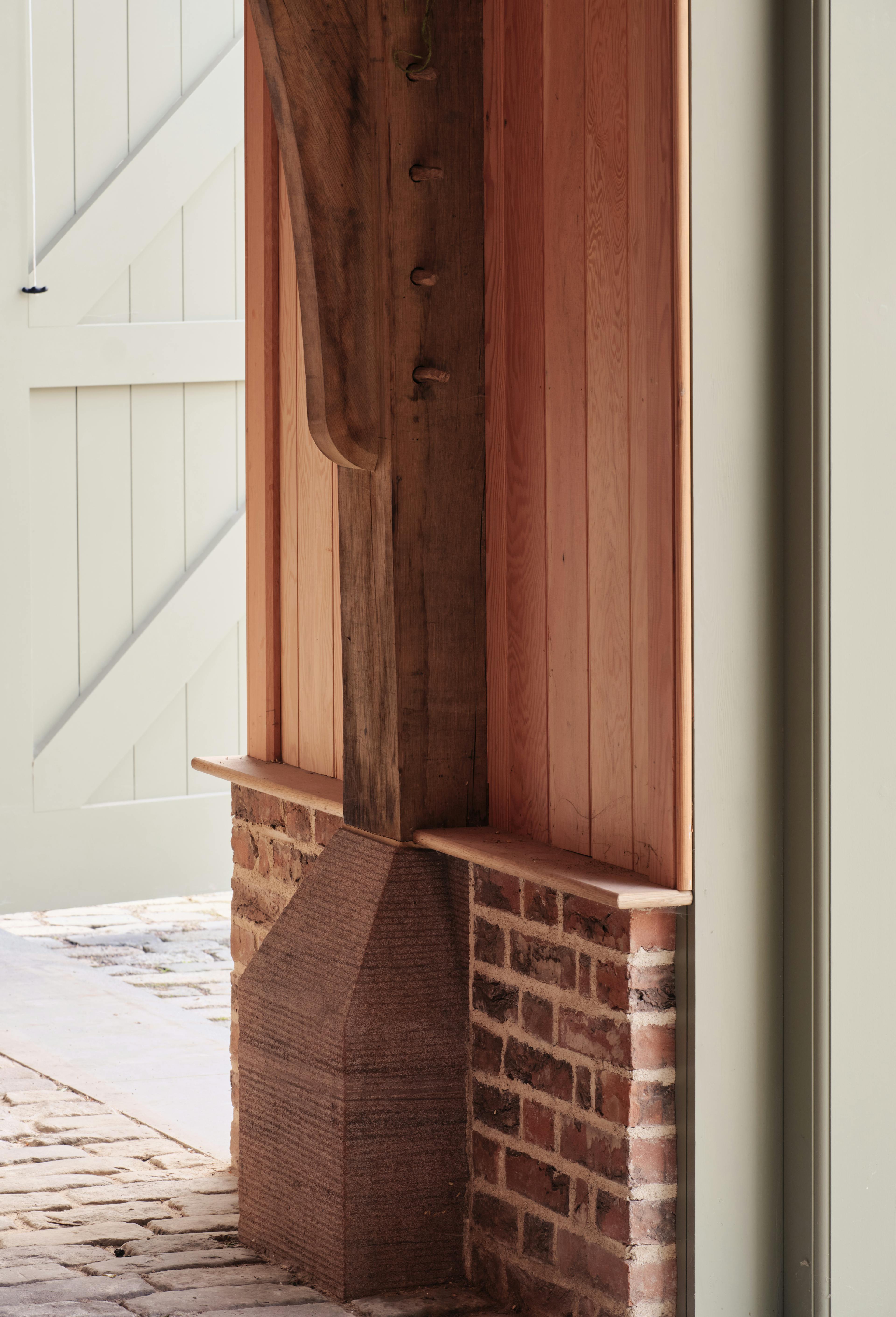 Integrated staddle stone incorporated into the wall construction of an oak-framed barn