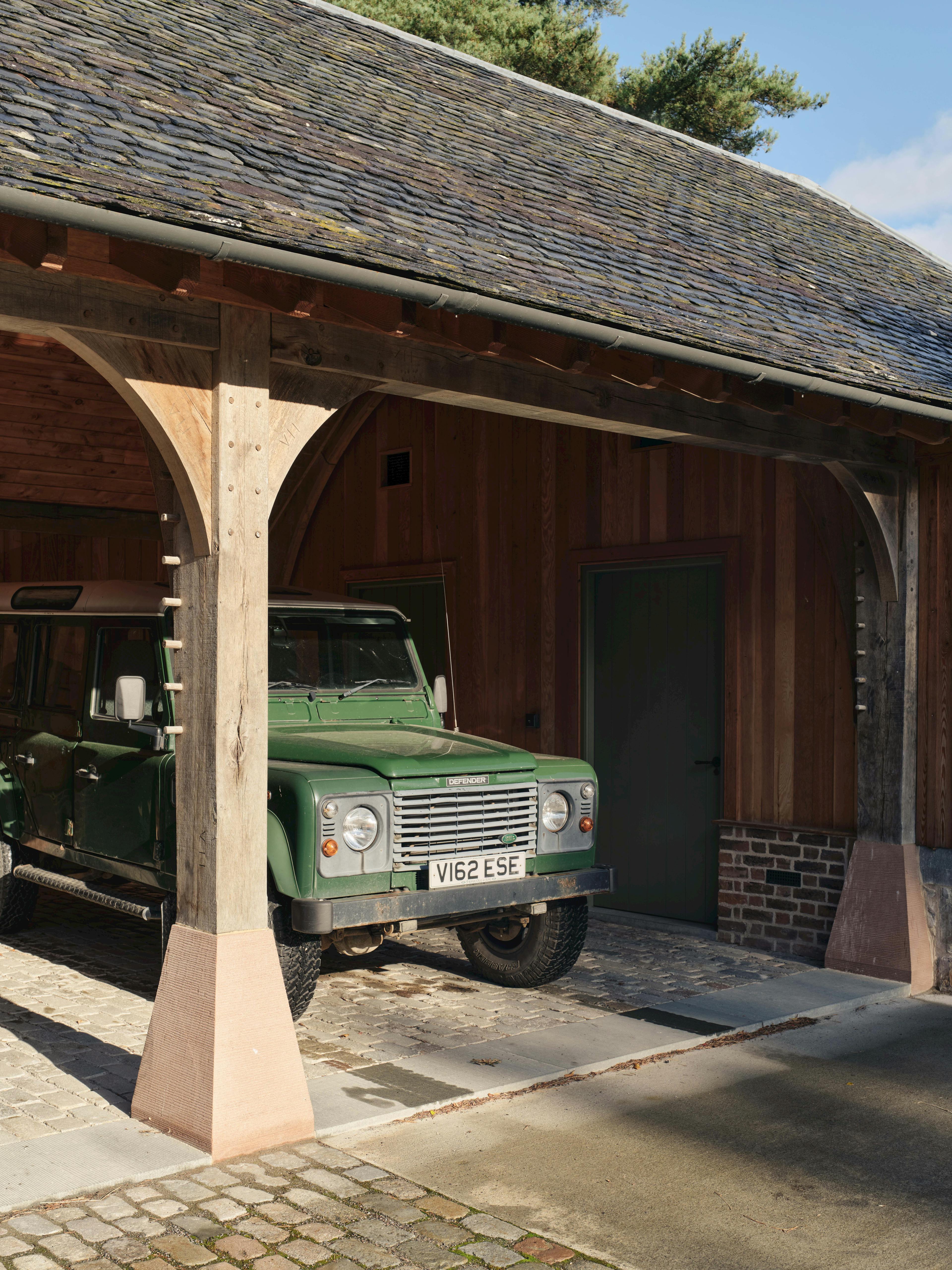 Oak-framed garage with concrete staddlestone features, combining modern and rustic architectural styles