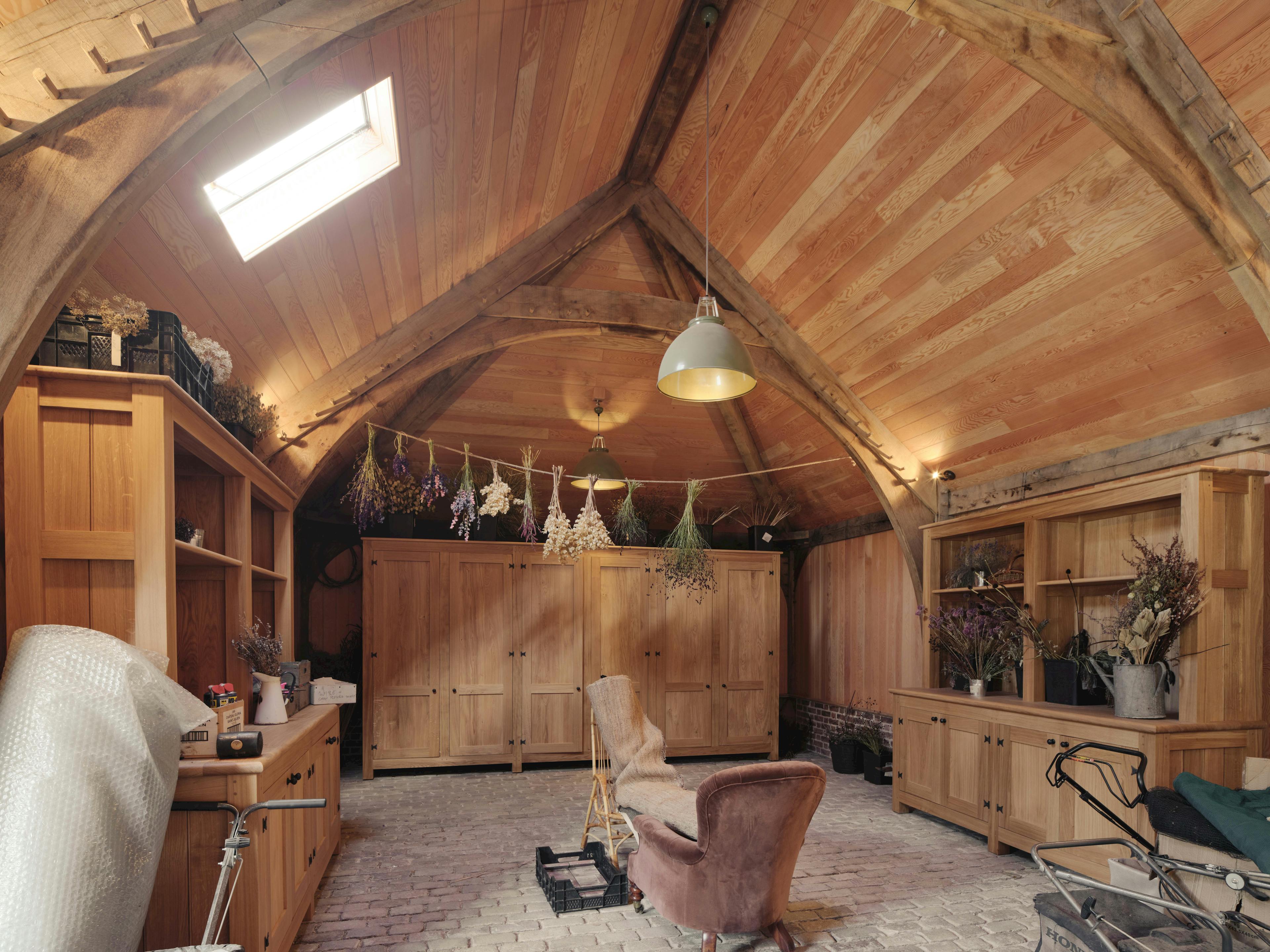 Interior of a traditional oak-framed space used as a multifunctional area, including a pantry for food and storage
