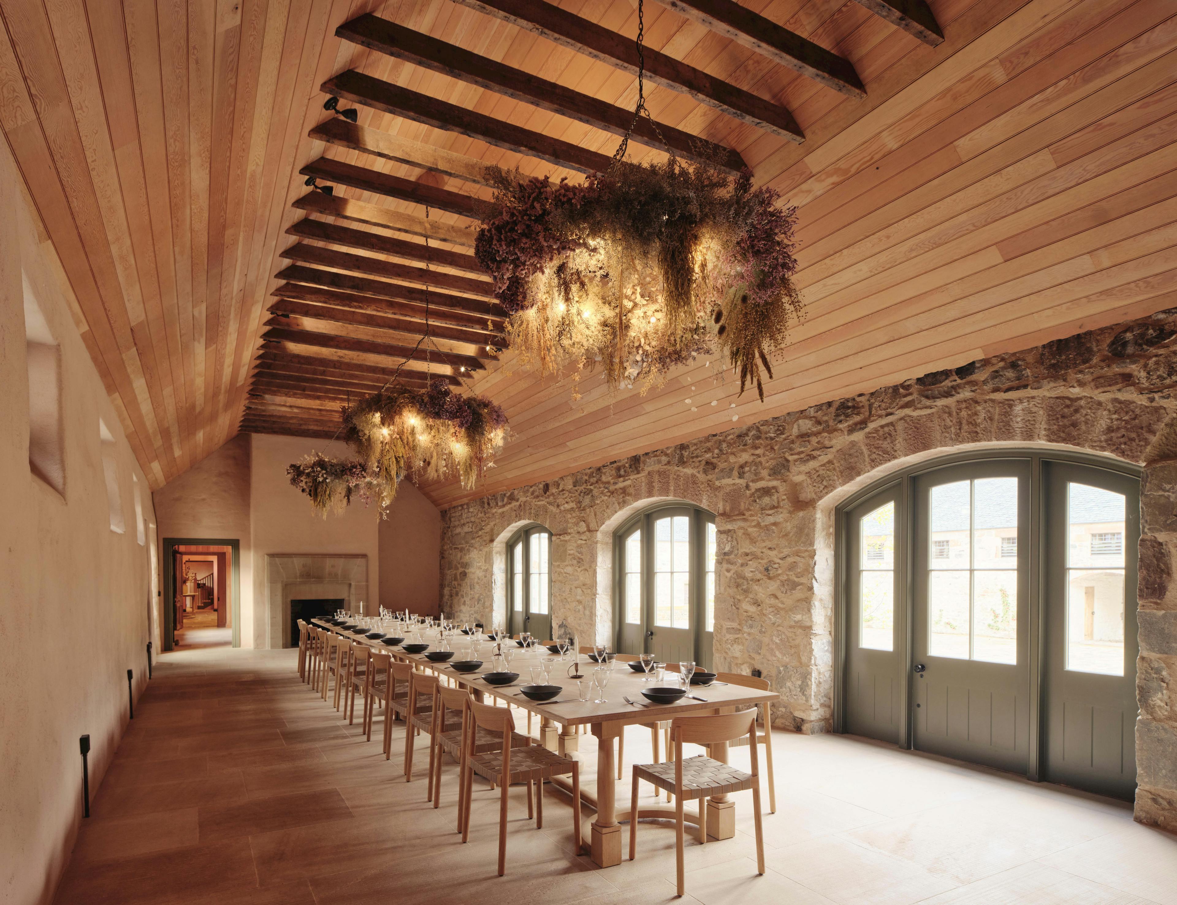 Interior view of a dining room inside a timber-framed building at the Aldourie Estate, showcasing traditional construction and design