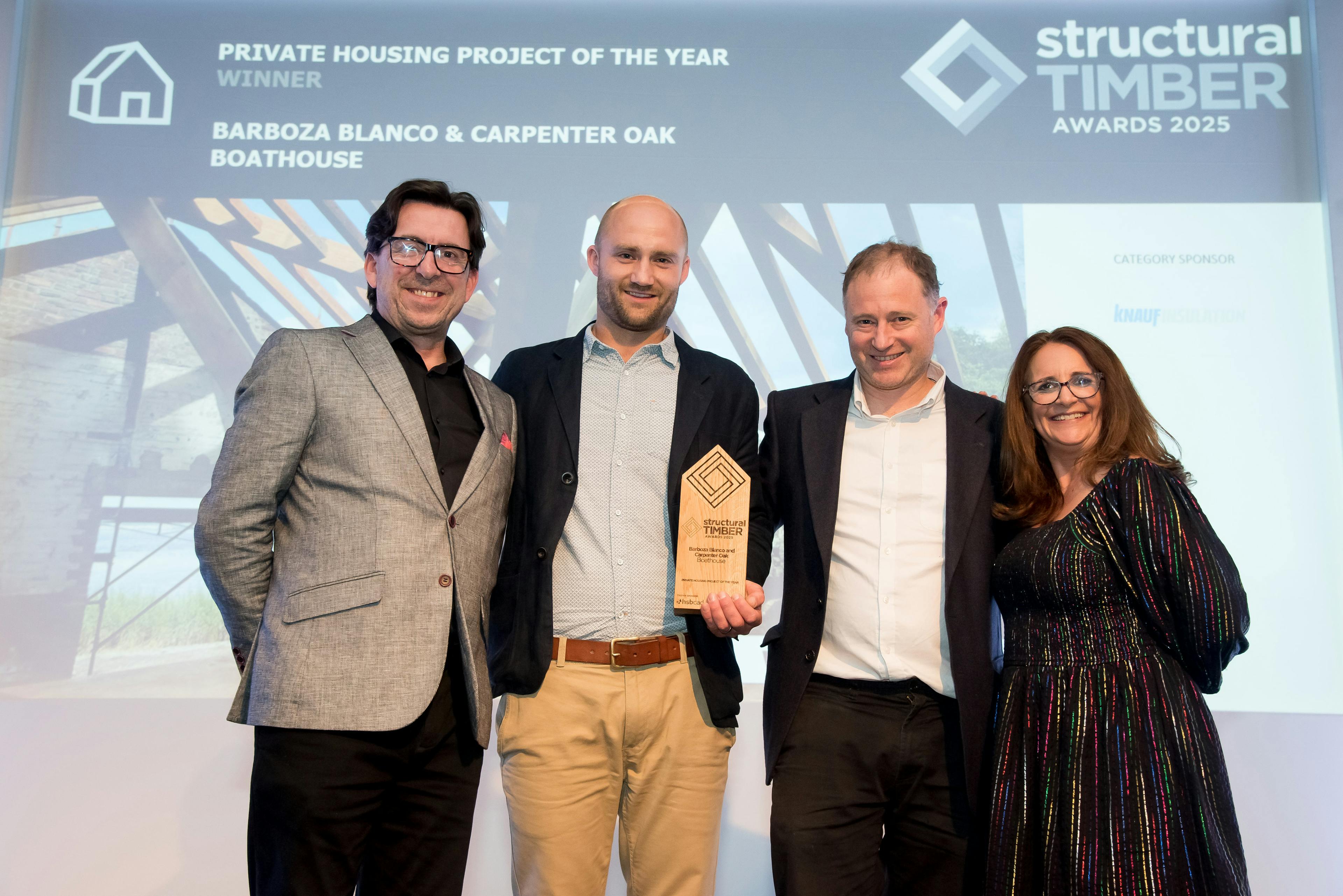 Four people on a stage collecting an award