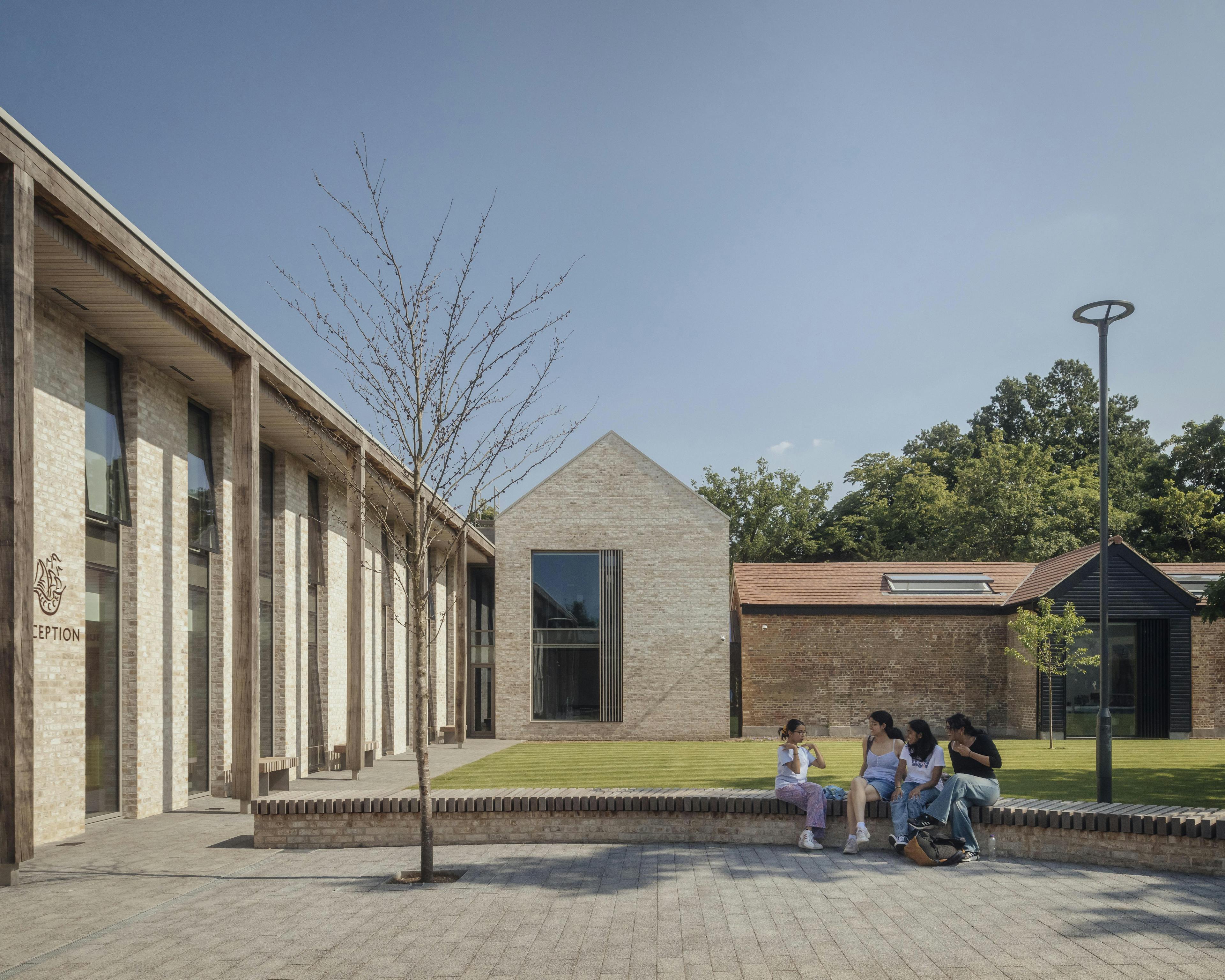 School children in uniform outside a school building with an oak pergola