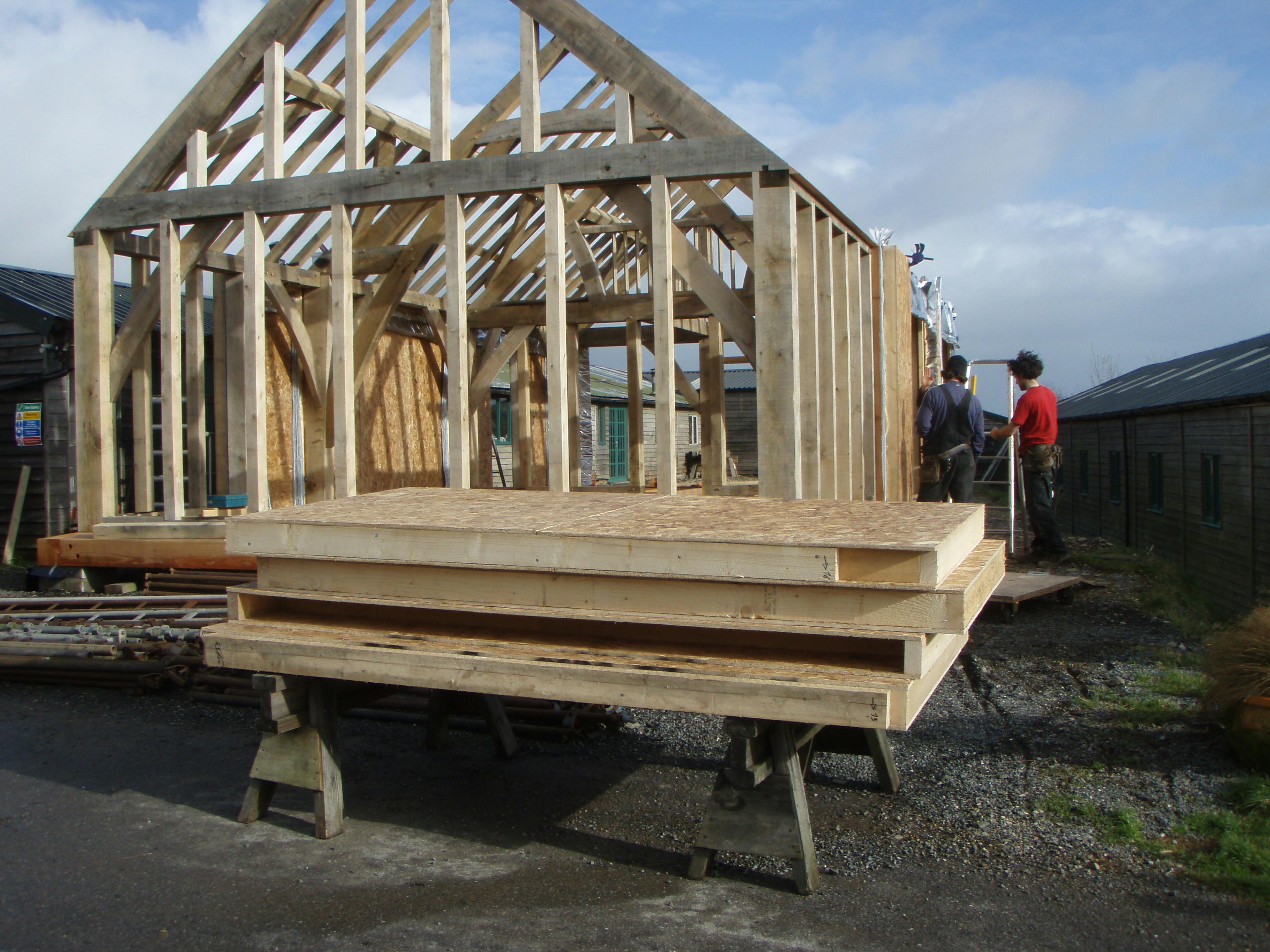 Carpenter Oak show barn in East Cornworthy with structural insulated panels (SIP) being installed, highlighting the building’s frame and construction process