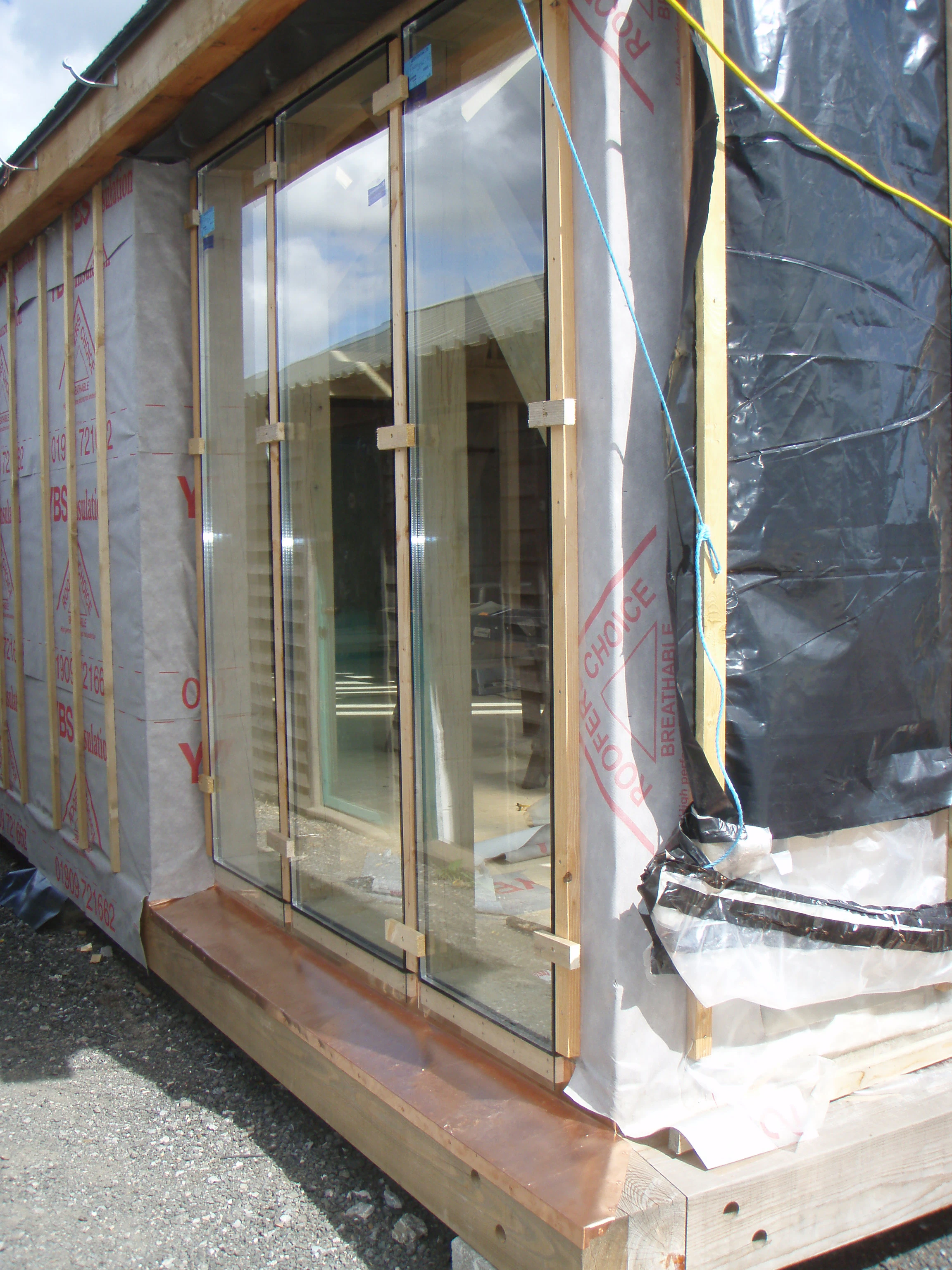 Direct glazing installation at the Carpenter Oak show barn in East Cornworthy, highlighting precise fitting, timber frame structure, and craftsmanship