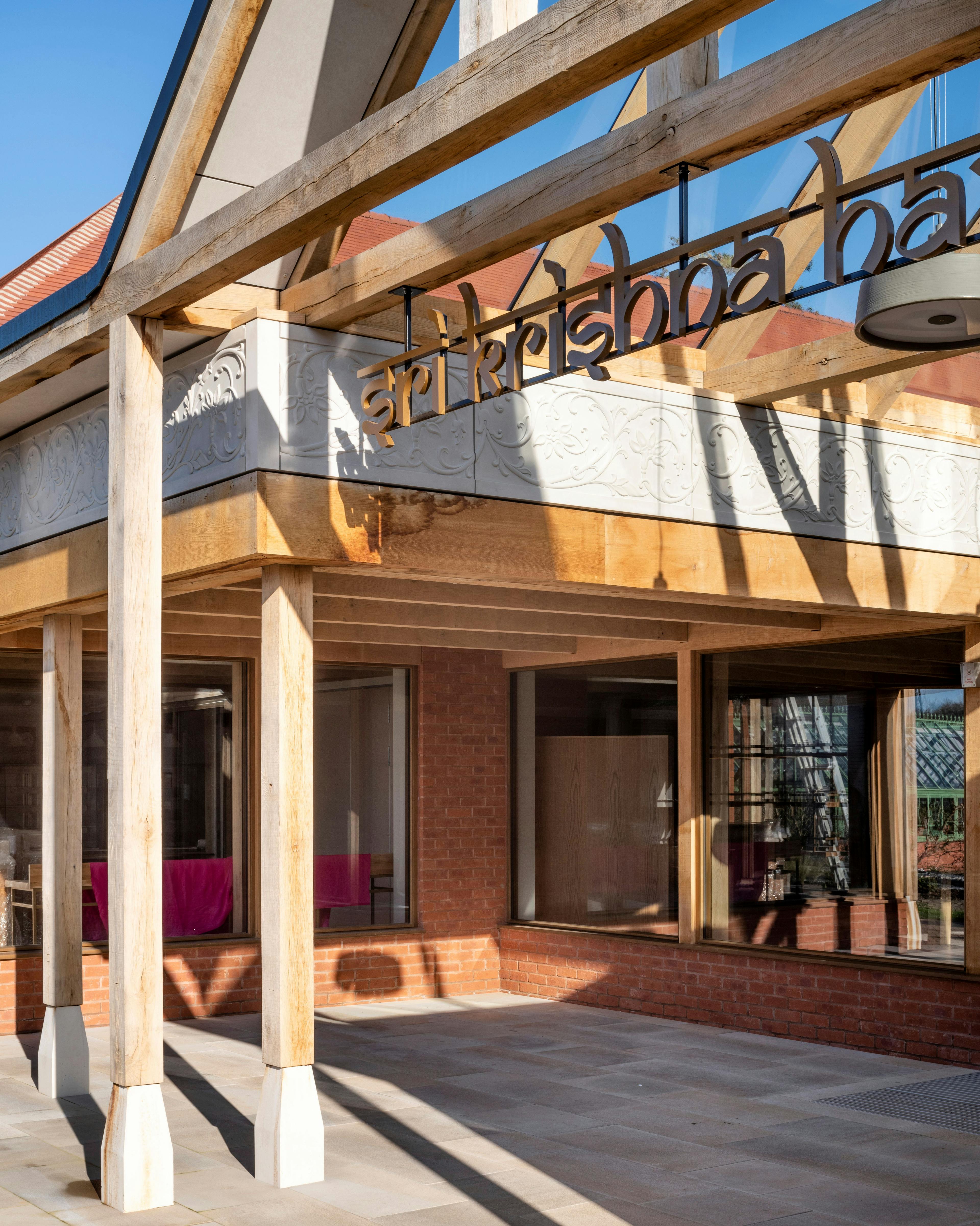 A green oak framed entranceway of a Hindu Temple